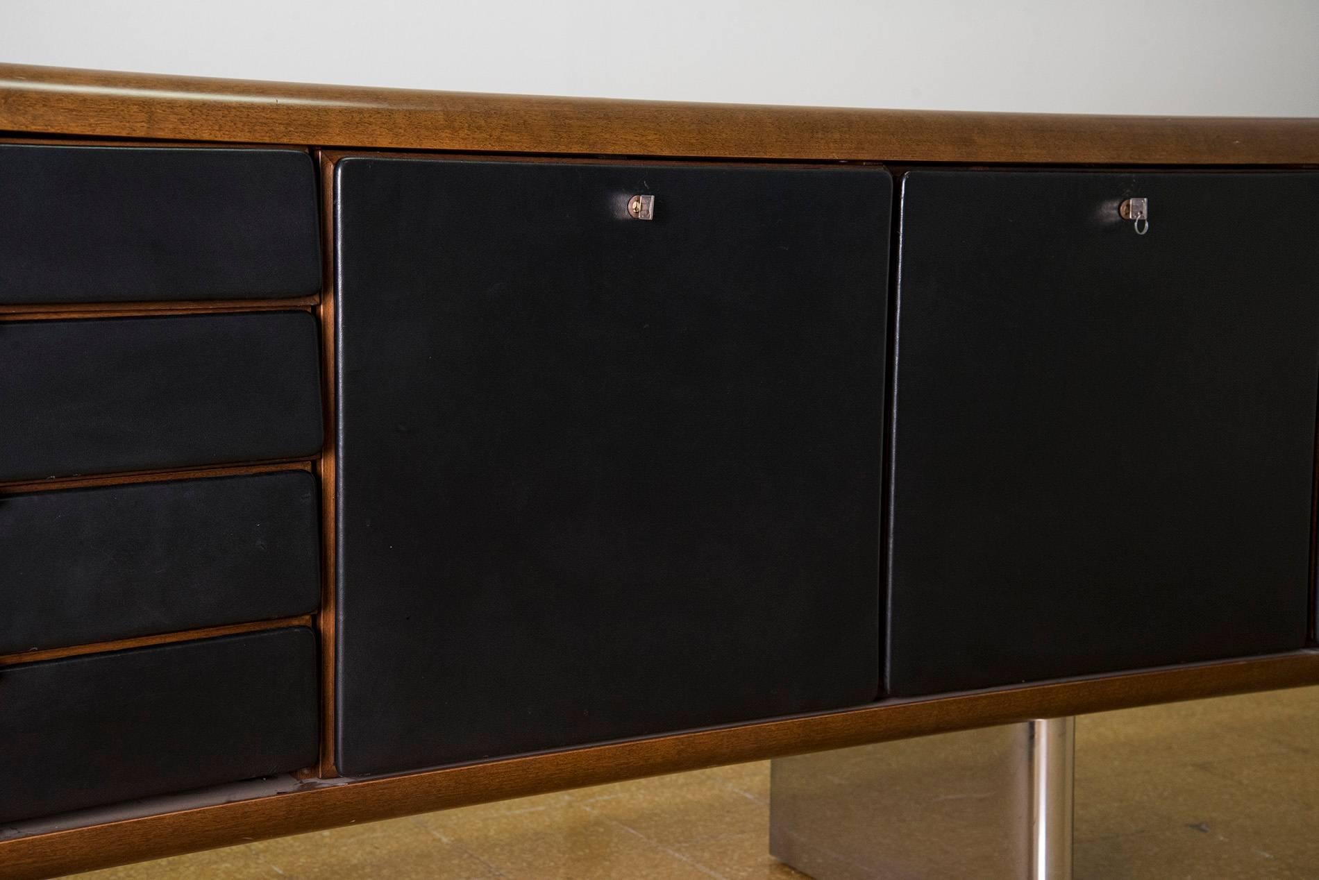 Pair of large sideboards designed by Hans Von Klier for Skipper in 1970. Stainless steel legs, walnut structure, doors and drawers covered with black leather. Four drawers and three cabinets with shelves and organizing elements. Good original