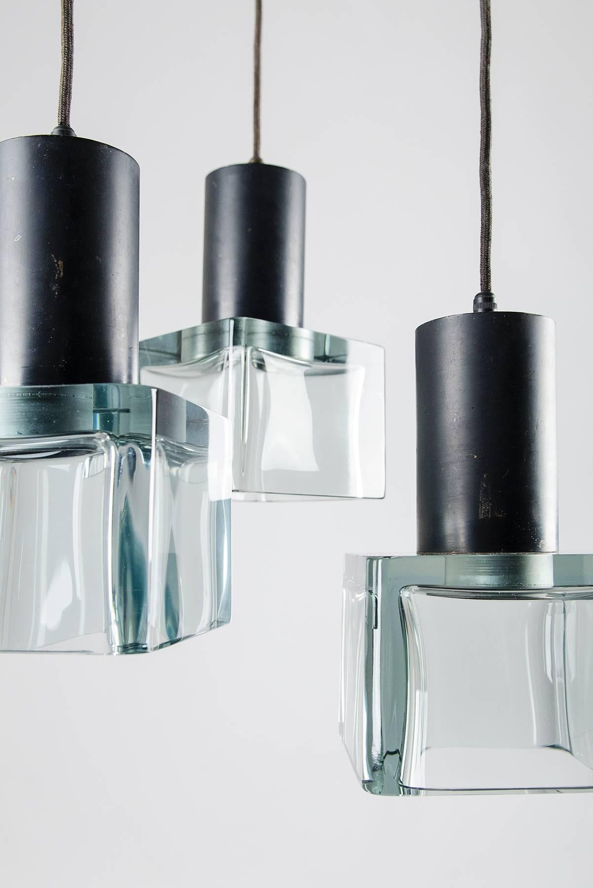 Three-pendant chandelier manufactured by Seguso, Italy, in the 1960s. Massive Murano glass diffusers with black lacquered metal structures. The height of the pendants can be adjusted according to need. The dimensions of each pendant are cm 13 x 13 x