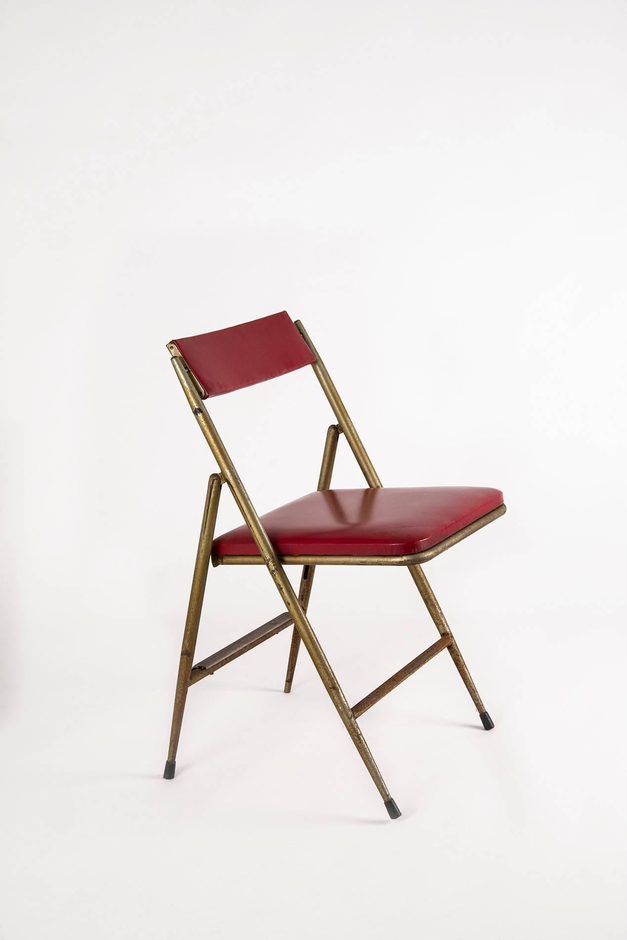 Pair of extraordinary folding chairs designed by Gio Ponti, manufactured by Cagliani e Marazza in the 1950s. Painted tubular iron structure, upholstery covered with red faux leather (resinflex), metal back feet-rest. Massive patina on the frame,