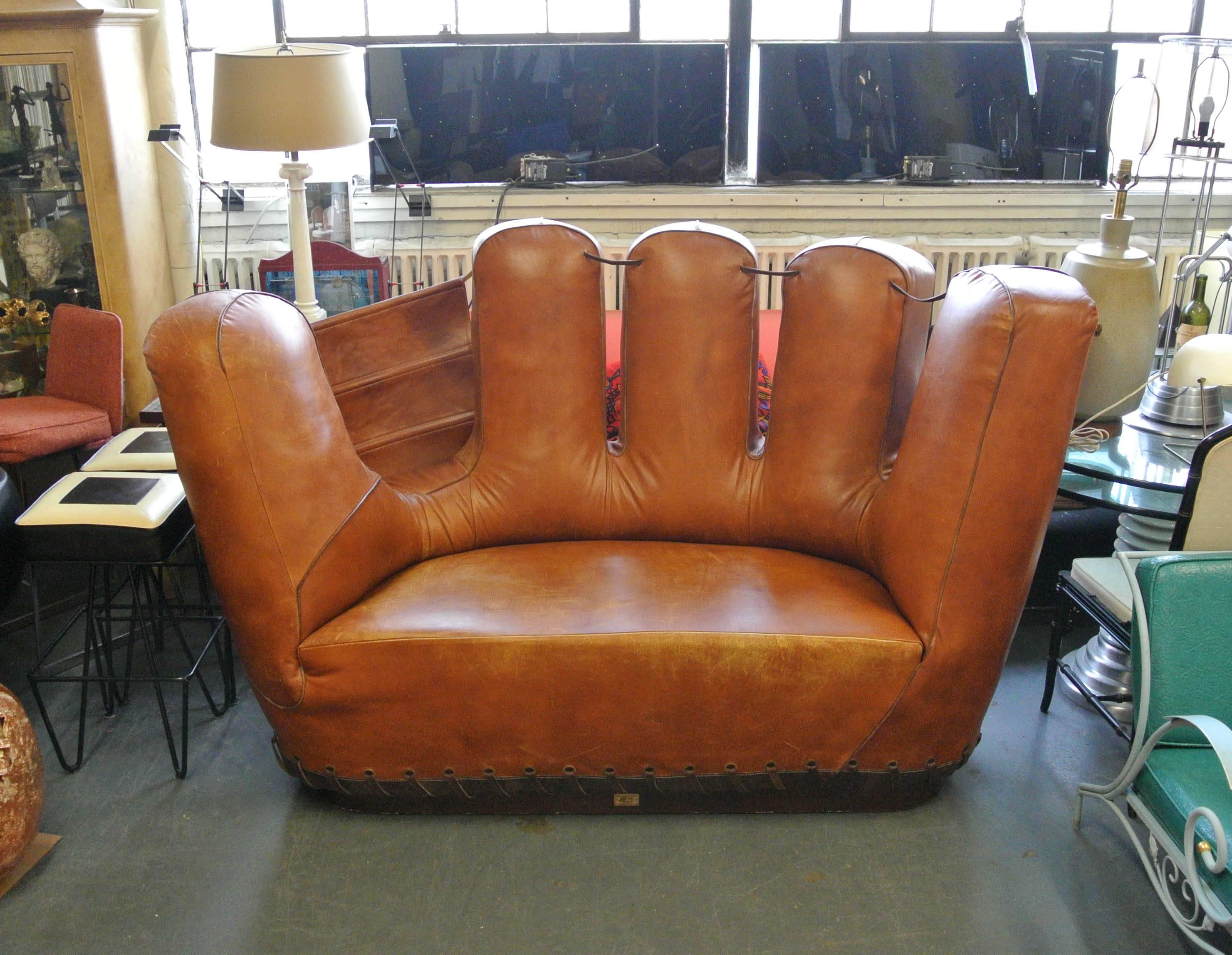 Being offered for your consideration unique Stiles Brothers leather baseball glove sofa or loveseat. Very well-made and sturdy with wood base and quality leather. In the style of Joe Colombo and if you really use your imagination Claus Oldenburg.