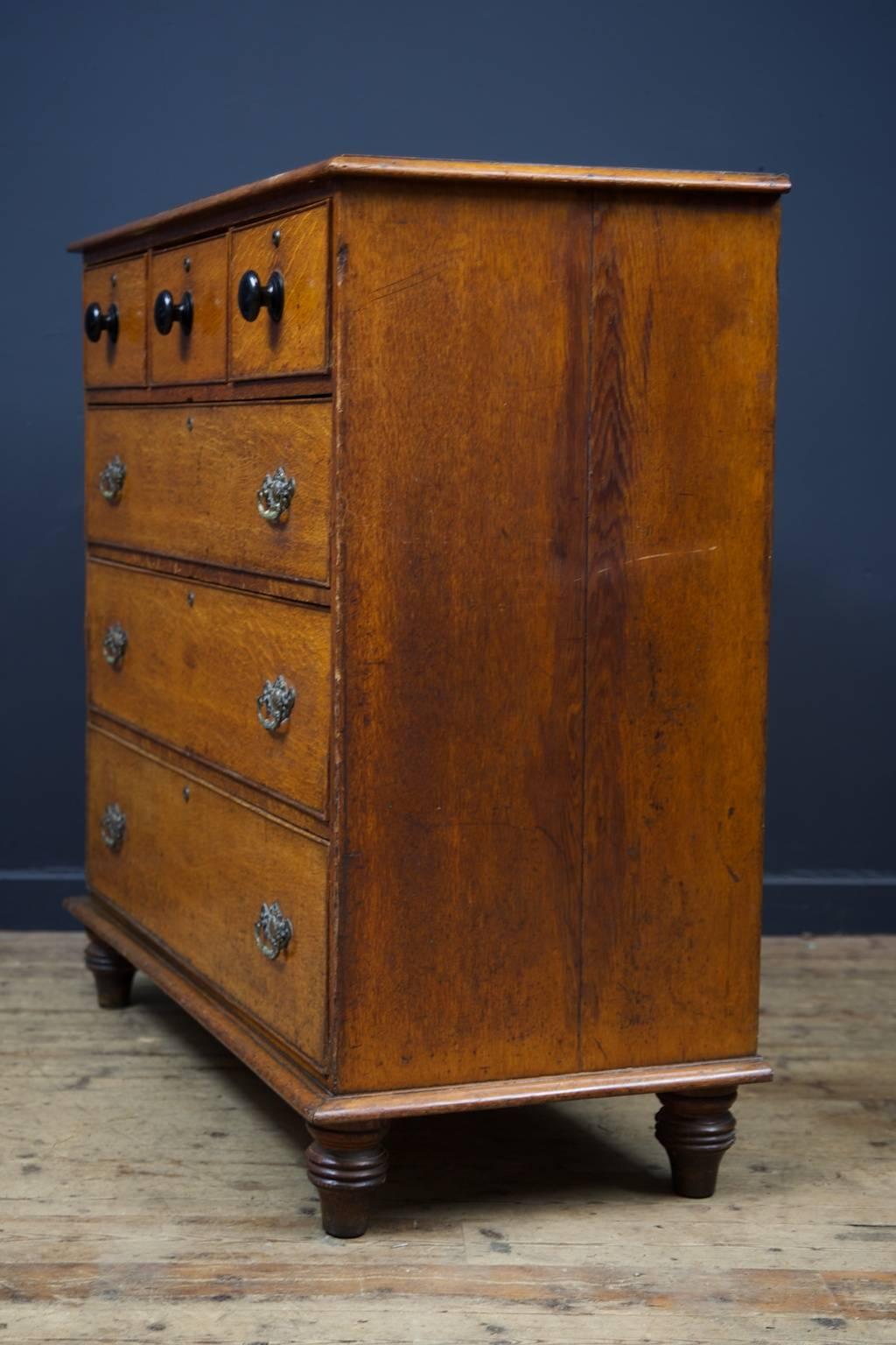 A gentleman's oak chest of drawers.

Extremely original and of excellent proportion, quality and color.

Three single drawers with turned and ebonized handles above three graduated drawers all with there original drop handles, raised on turned