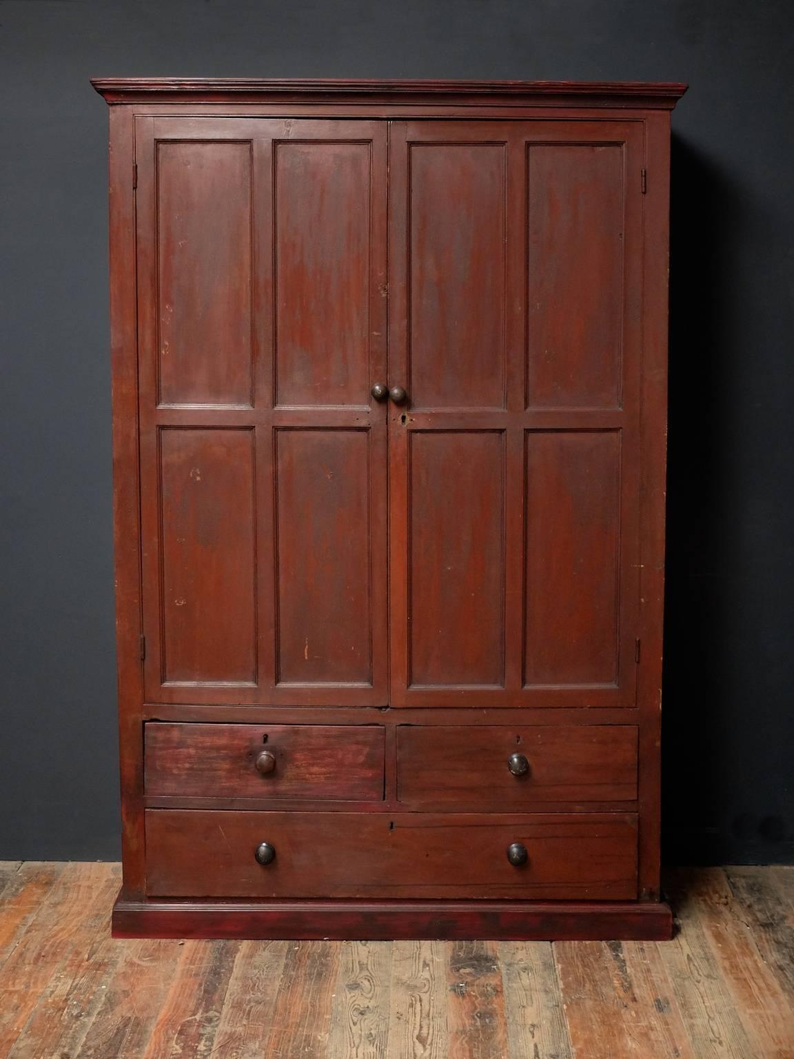 A painted pine cupboard.

Twin panelled doors with open shelving behind above two short and one long drawers to base.

Irish, circa 1900.

Restoration to the plinth.