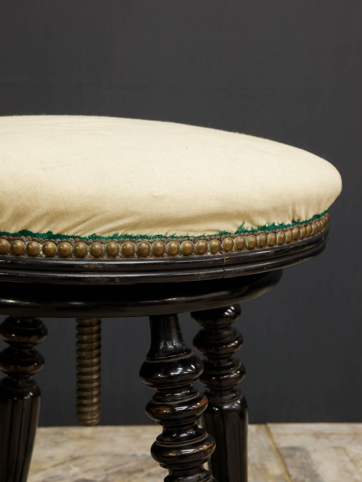 A large adjustable ebonized stool.

Incredible original ebonizing, horse hair stuffed linen seat, turned legs and cross stretcher.

English, 1870s.
 