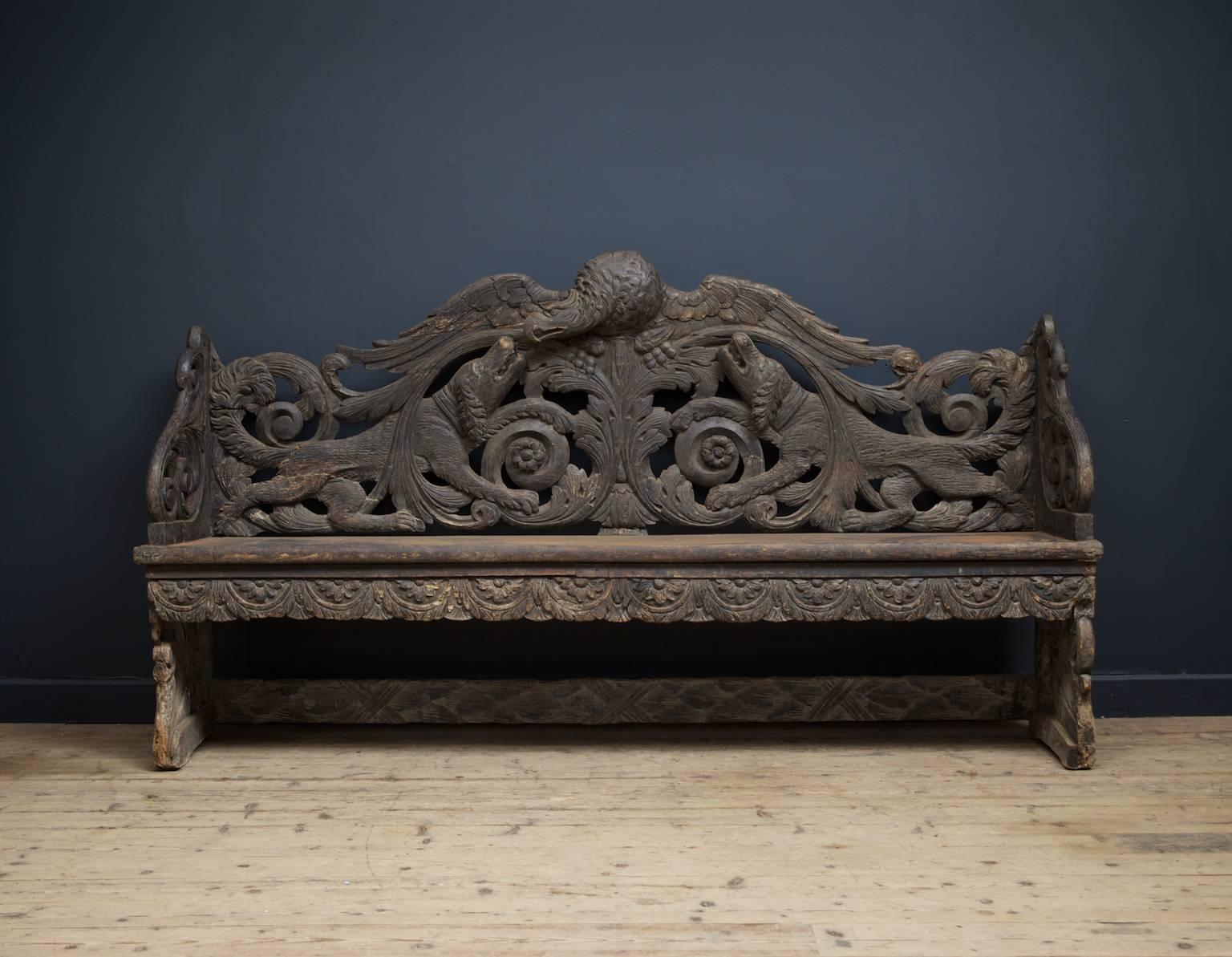 A carved and painted pine hall bench full of hunting motifs.

The back panel has a large eagle at the centre with two hunting dogs below, surrounded by spiralling foliage and acanthus.

Provenance: Craudfurdland Castle, Kilmarnock.

Northern