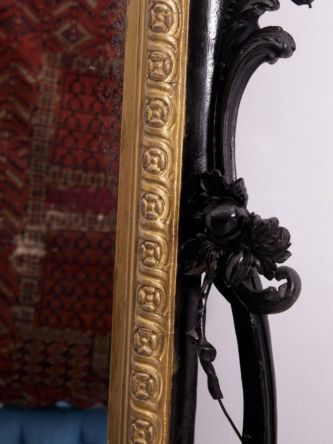 A large overmantel mirror.

Very well marked original mirror plate.

The carved timber and gesso frame over painted and with losses and damages.

English, 1870s.