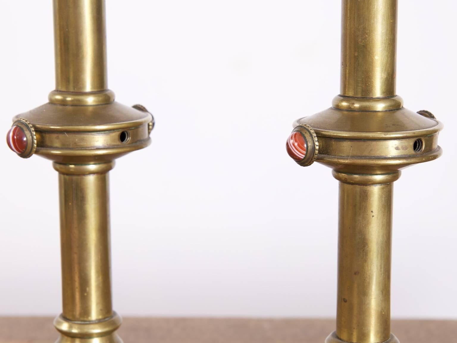 A pair of brass Gothic Revival candlesticks.

Two Cabachon missing from each,

English, 1880s.
 