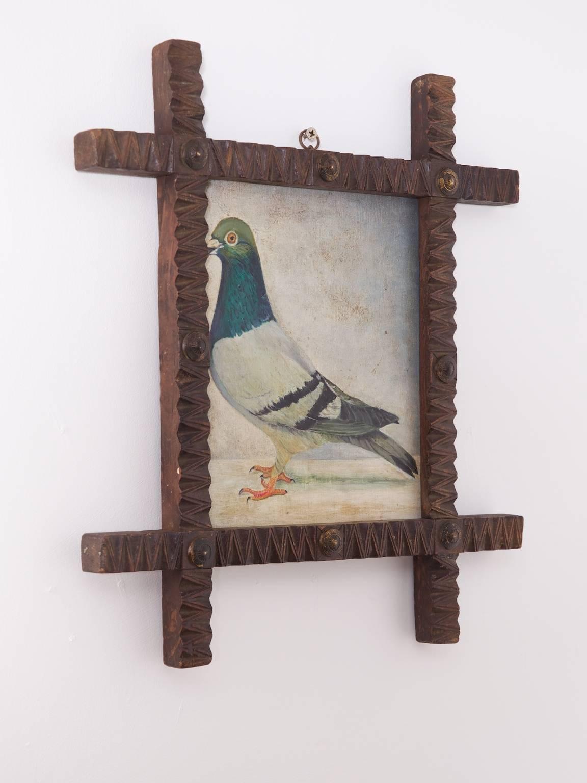 A naive oil on board painting of a prize pigeon set in a Folk Art frame with brass roundels.

English, circa 1860.