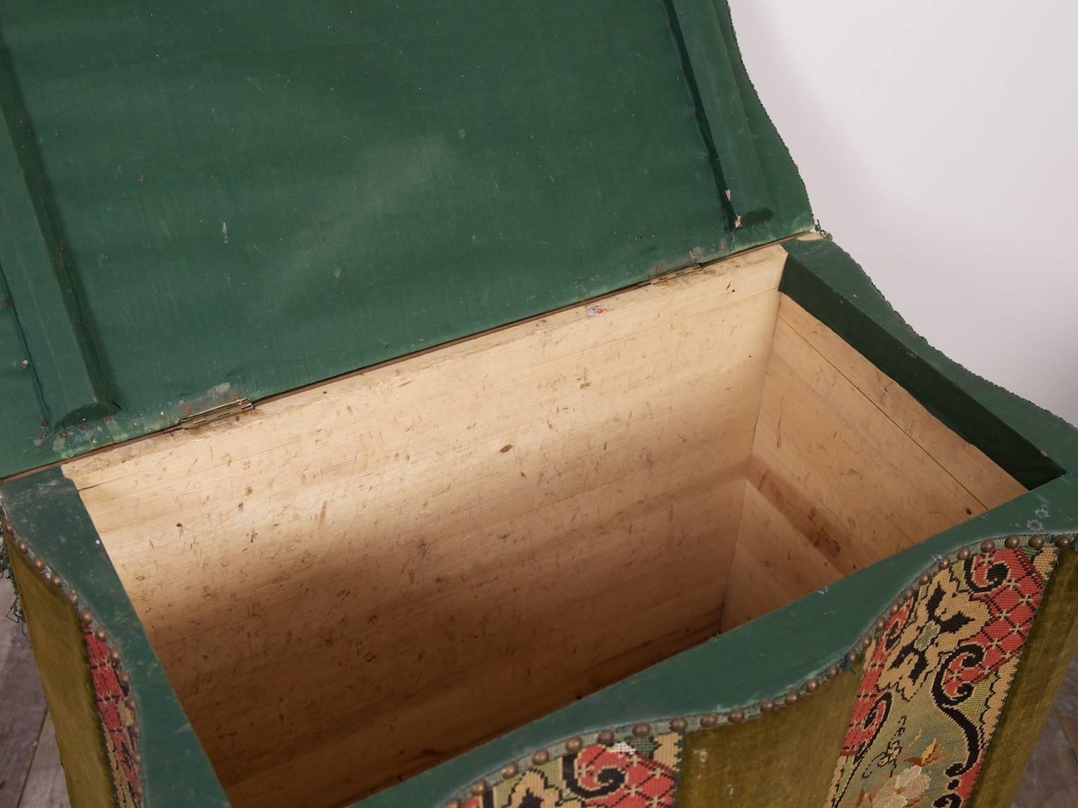 A serpentine blanket box raised on leather castors and covered with velvet and tapestry,

English, late 19th century.
 