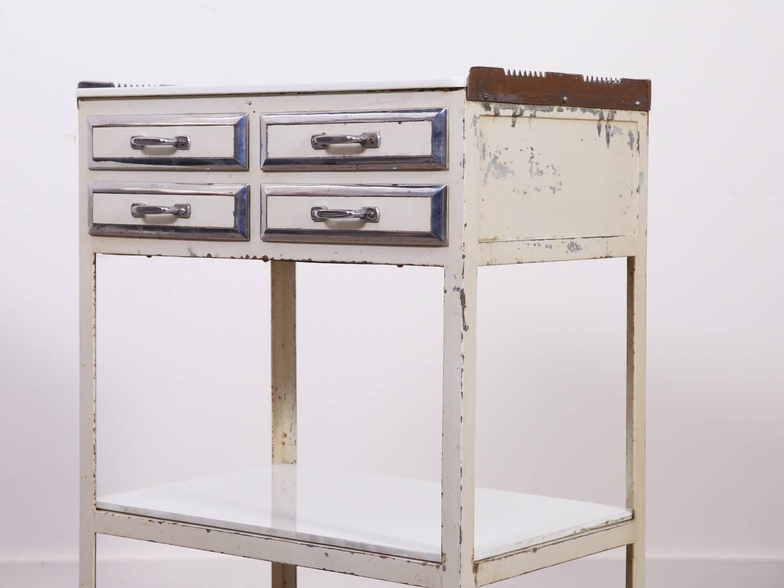Painted steel dentists trolley.

White vi troilite top and low shelf, four nickel trimmed drawers with glass liners,

1930s.

Super build quality, make a fabulous drinks trolley.