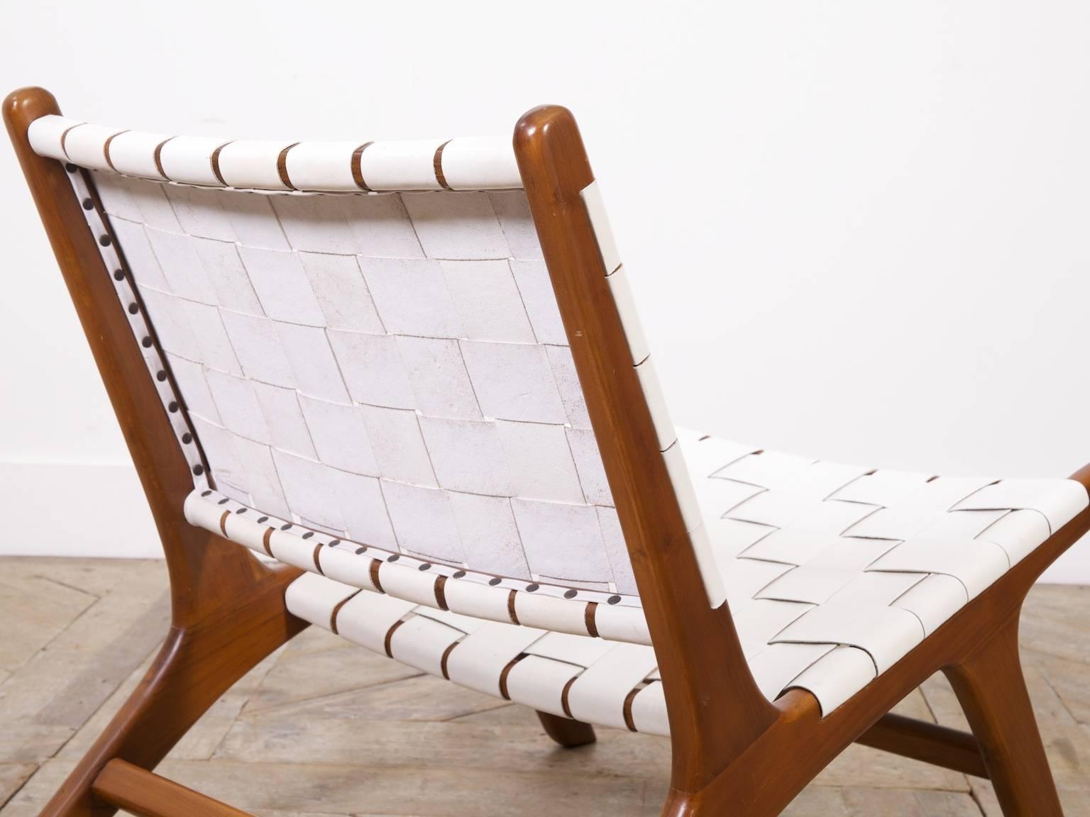 A pair of teak and white leather Italian lounge chairs.

Italian, late 1960s.