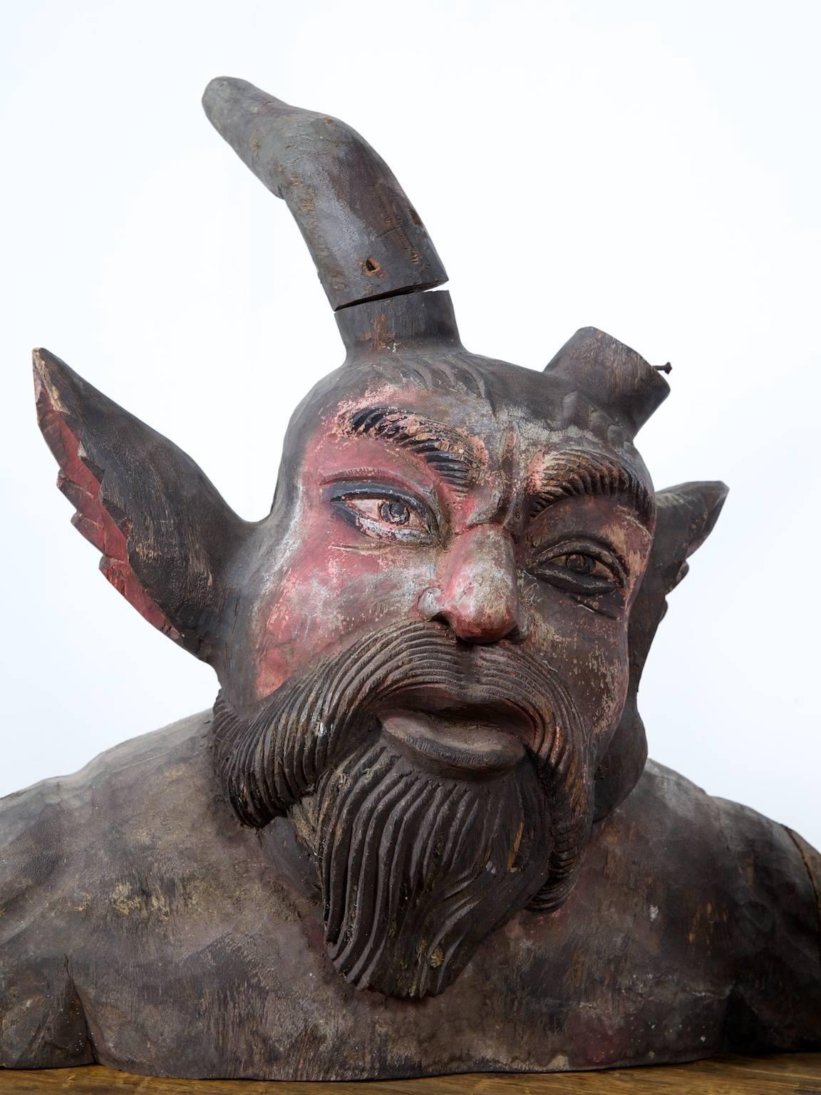 A pair of large carved American redwood bearded Devil busts.

The pair retain a lot of the original painted surface, there is a single horn included but not attached, the other is lost.

Busts of this type were fitted to the front of Showmans