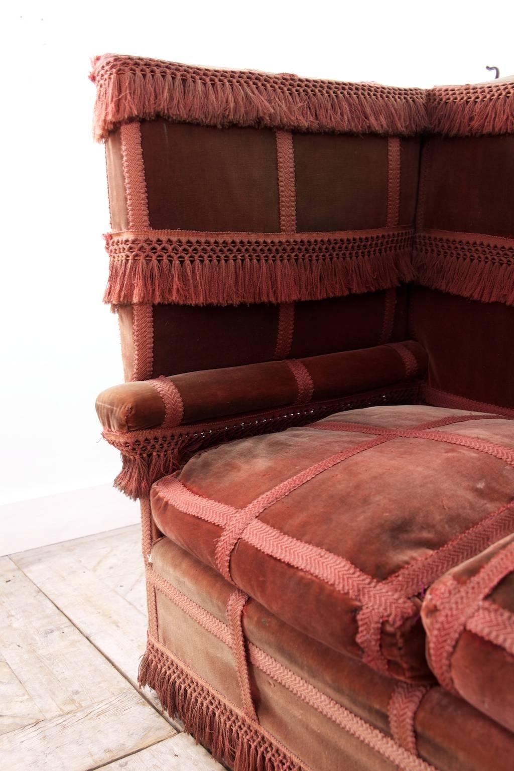 A red velvet Knole sofa.

Steel ratchets to both drop arms, all original upholstery and fringing,

English, late 19th century. 

Measures: H 108, W 192/290, D 78 CM.