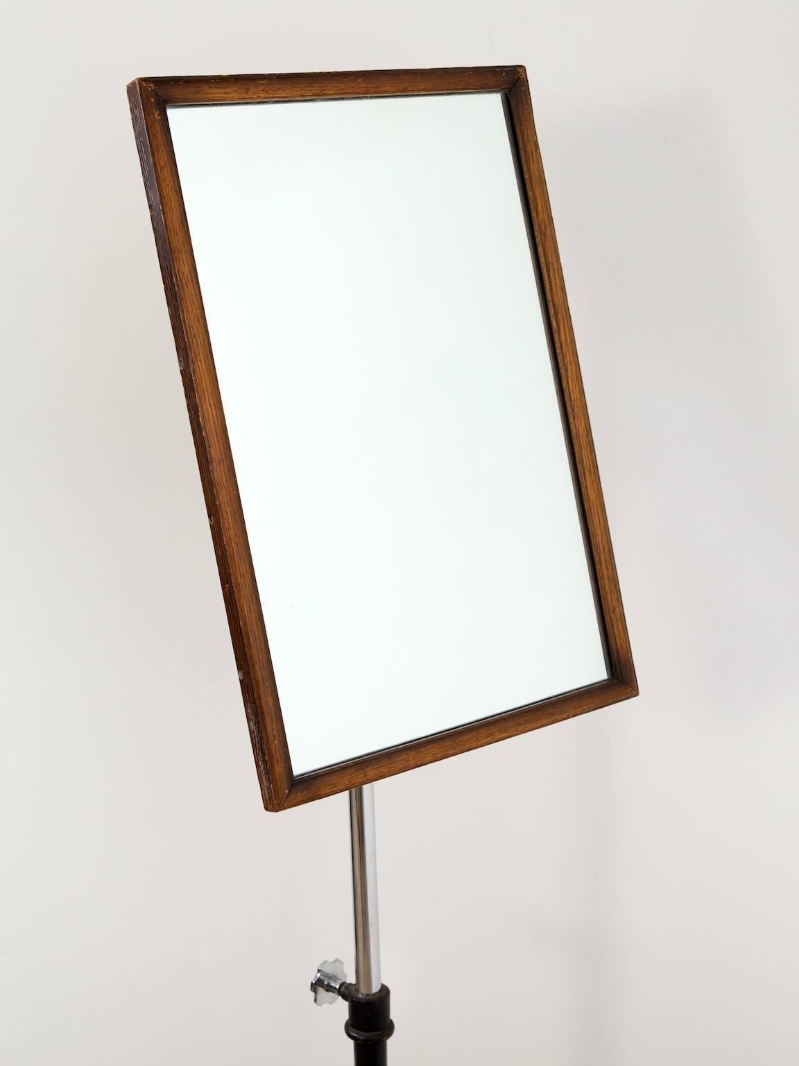A clothing outfitter's adjustable mirror.

Black japanned cast iron base with adjustable chrome to support the mahogany framed mirror plate.

English, 1940s.
  