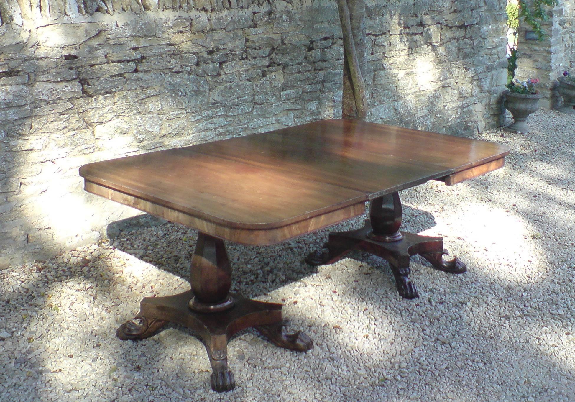 Early 19th century mahogany twin pillar antique dining table standing on four splay platform base, made of very good cut of timber with excellent grain pattern and with original leaf. Can take another leaf if required, 

English, circa