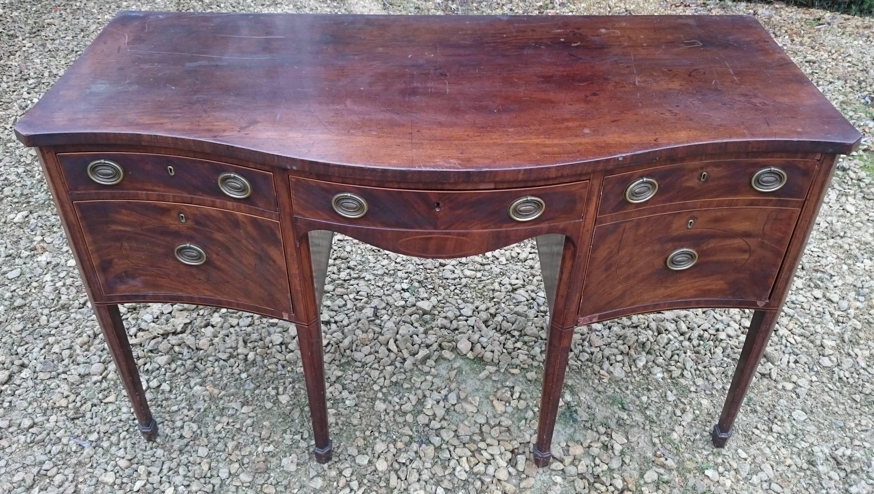George III period mahogany serpentine fronted sideboard. This sideboard has a wonderful patina that will come up very nicely when our workshop had buffed it with beeswax. The front is flame mahogany with stringing in box and ebony. The legs have an