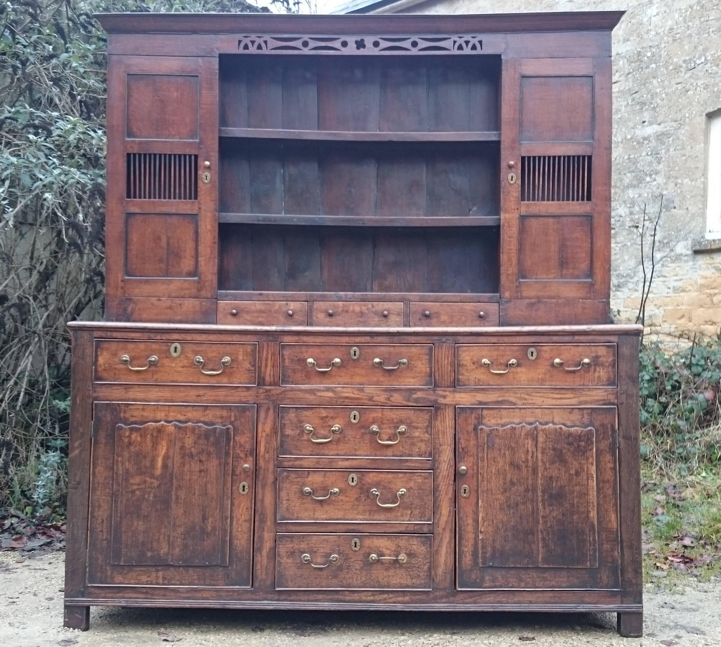 George II period 18th century oak dresser. This dresser provides lots of lovely storage space while not being very deep front to back. The mouse resistant upper cupboards with bars on the doors are interesting. There are six large drawers and three