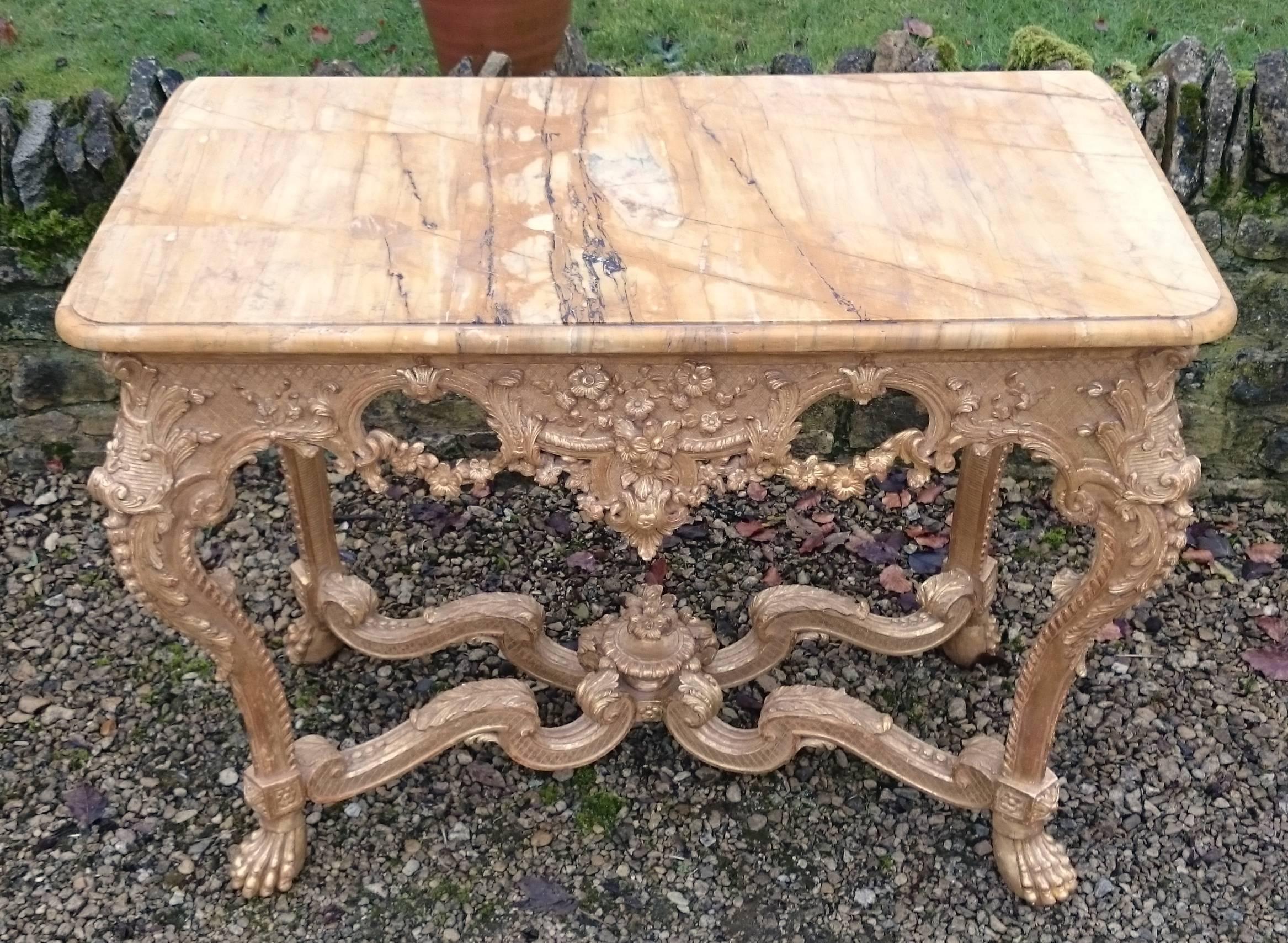18th century, George II period antique console table. This console table is very finely carved and decorated in the Rococo manner, with garlands of flowers, scrolls and generously shape to the cabriole legs, lower stretchers and frieze. The later