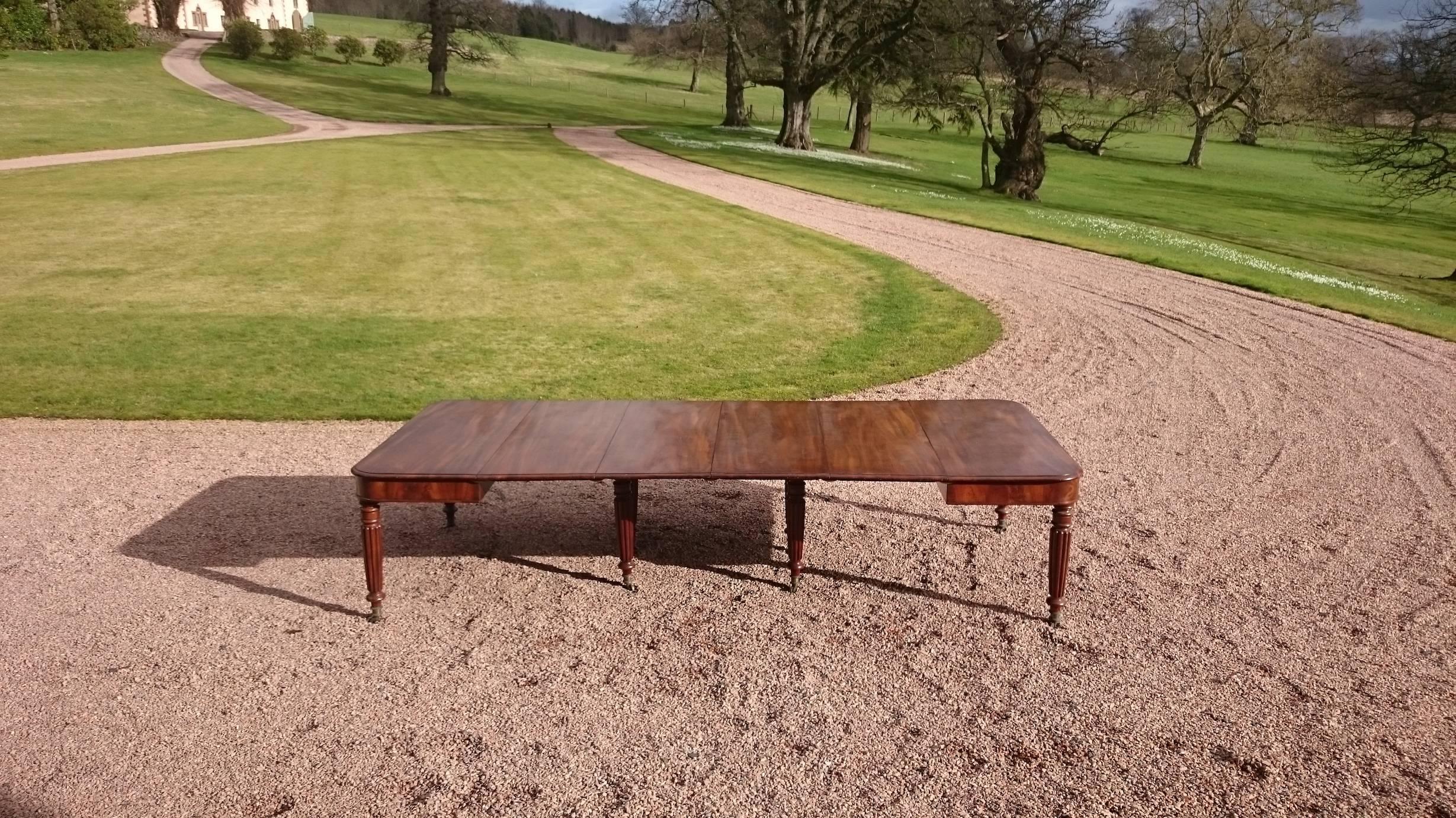 19th century George IV period antique dining table. This table is made of mahogany that has faded to a very desirable golden brown color with good patina. The legs are at the corners of each and tucked away in the centre so that no one has a leg in