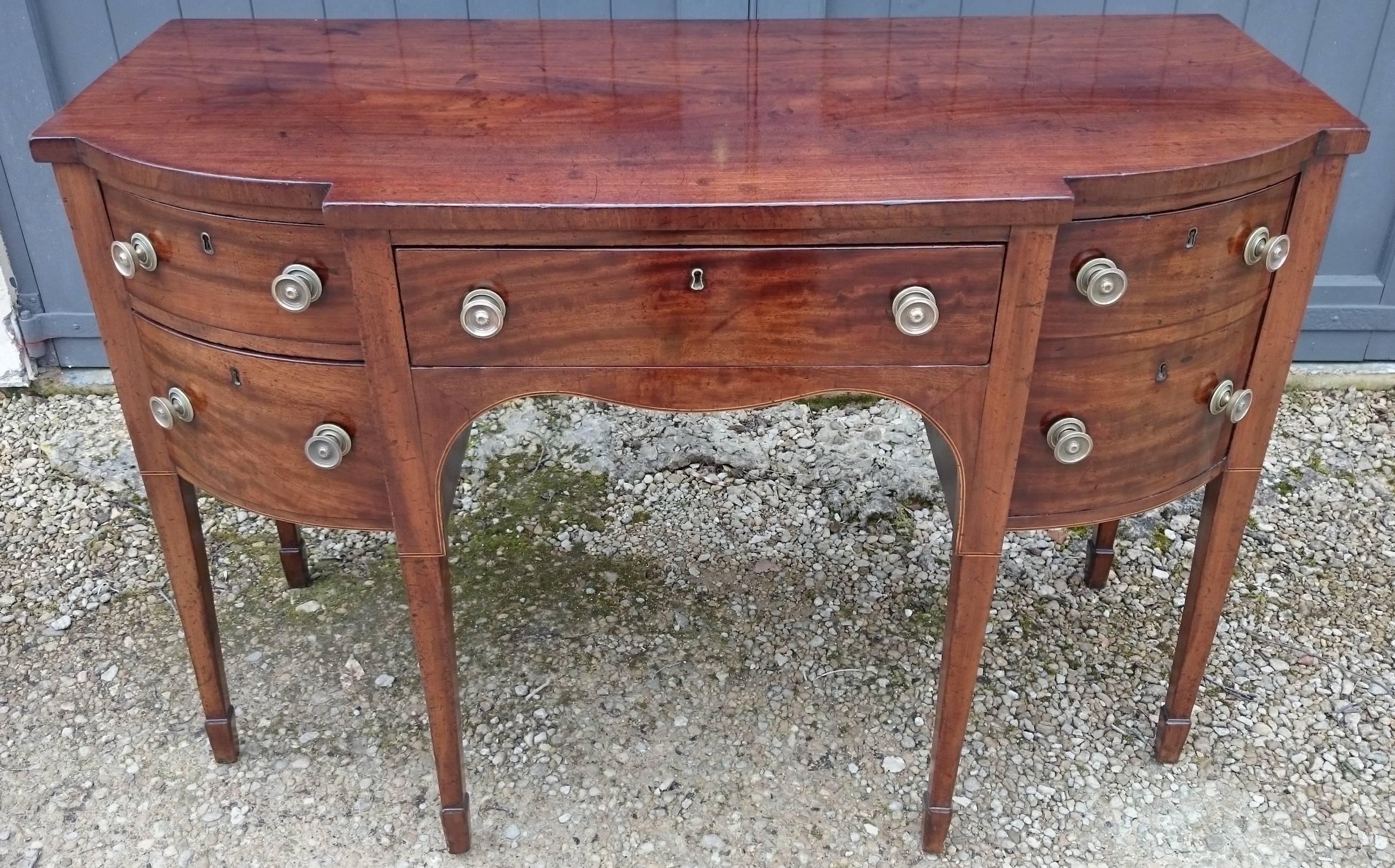 18th century George III period antique sideboard standing on six square taper legs with spade feet. This sideboard is made of a really Fine cut of mahogany with boxwood and ebony stringing. The mahogany has faded to a good pale color while retailing