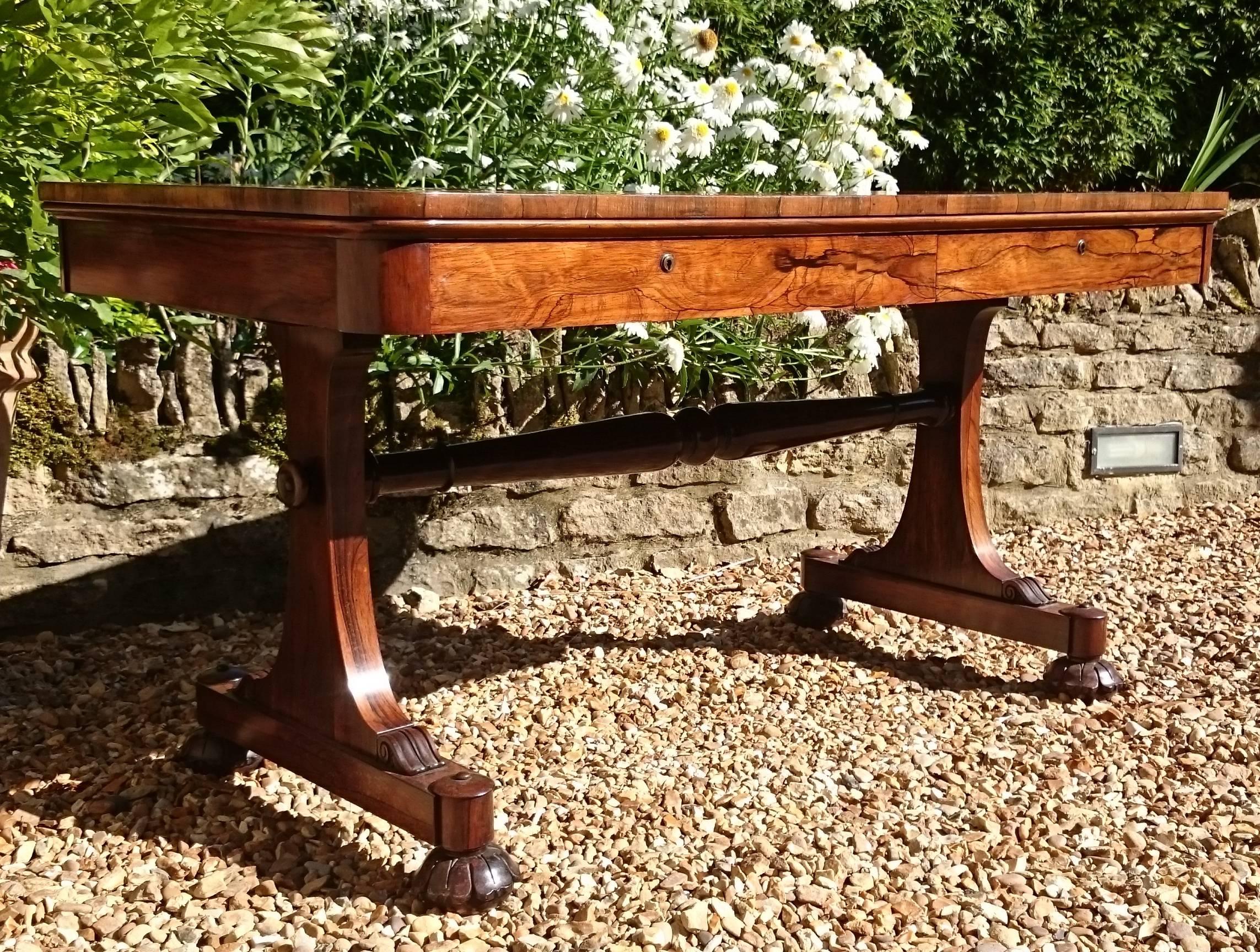 This is a very good antique library table dating from the William IV Period of the 19th century. It has all the things one could wish for in a library table; elegant end supports, fine carving, good golden brown rosewoood, mahogany drawer linings,