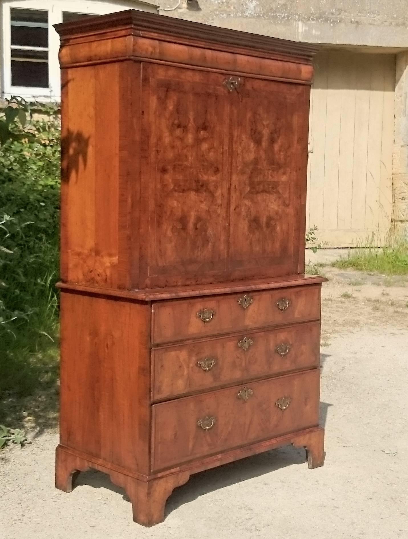 Early 18th century escritoire made of very fine sections of quarter cut walnut veneer with cross banding and feather banding. The fall front lowers to provide a writing surface revealing pigeon holes and many small drawers to the interior of the