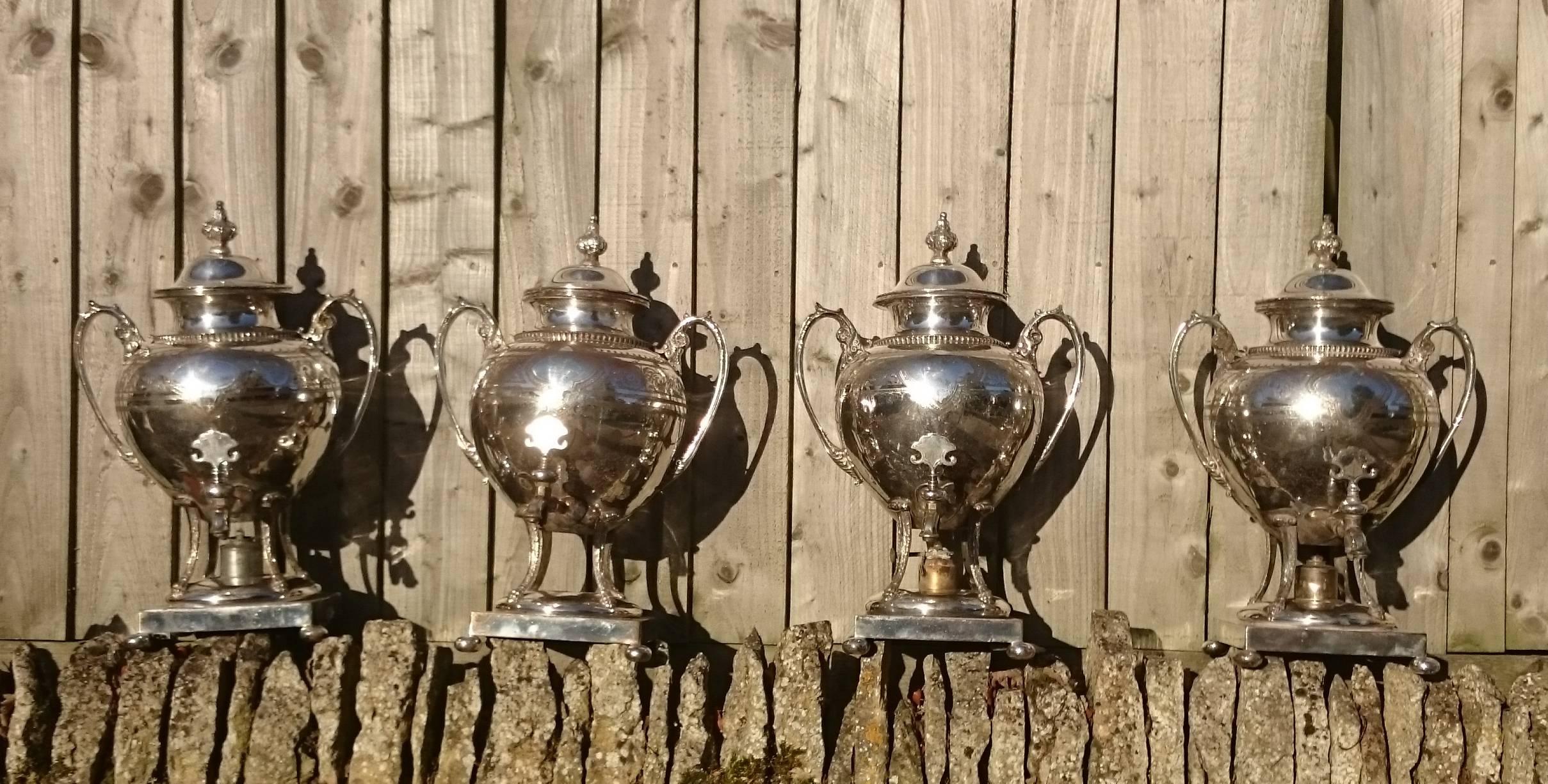 Very rare set of four large-scale antique electroplated kettles. These are fairly ornate kettles made after Rococo designs that would have been popular in the 1750s. The decoration consists of floral swags and scrolling and the top finial is of