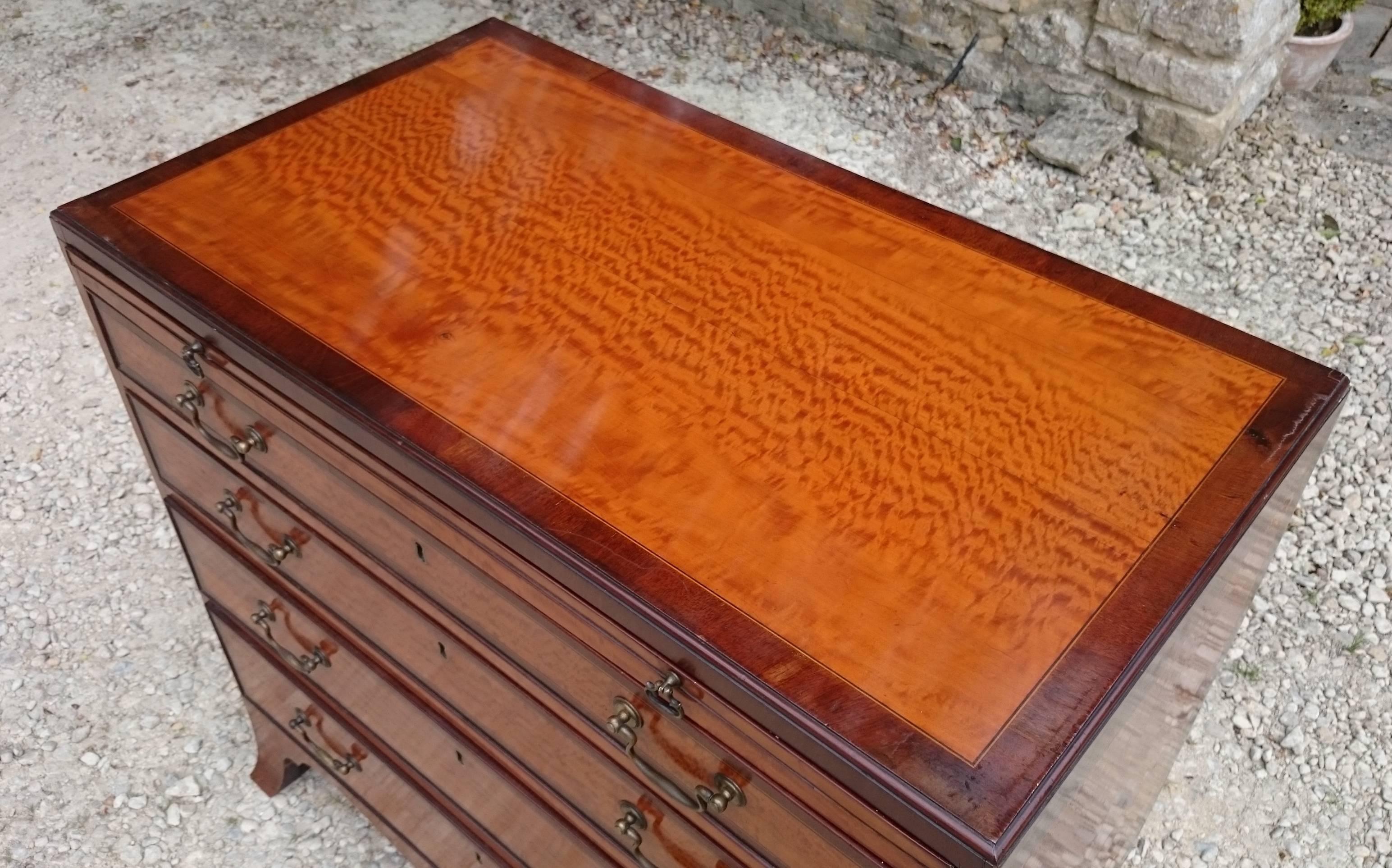 Most excellent chest of drawers made of amazing 3D satin wood with mahogany crossbanding to contrast the colour. It has oak lined drawers, a brushing slide, bracket feet AND a caddy top! Everything you could ask for in a 220 year old chest of