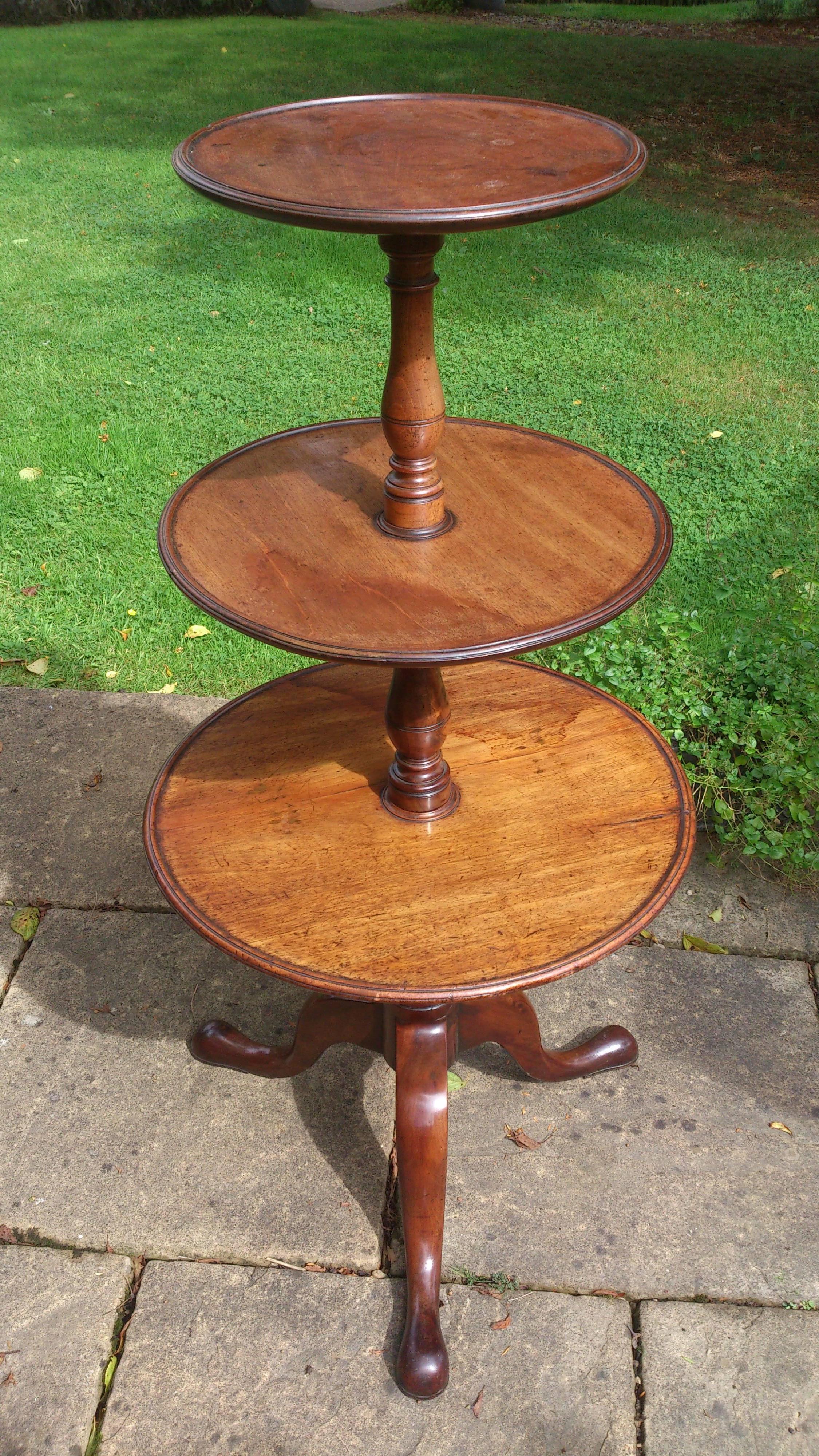 Charming George III mahogany three-tier antique dumb waiter or antique whatnot. Very useful at chair side for holding drinks, remote control, books or in the corner of a room to display plants or photograph frames. This is an elegant early version