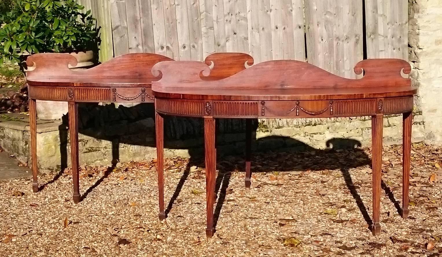 Very fine pair of early nineteenth century George III period mahogany antique console serving tables. This very rare pair of elegant side tables were made for a large room and they were designed to impress. They are typical of the late George III