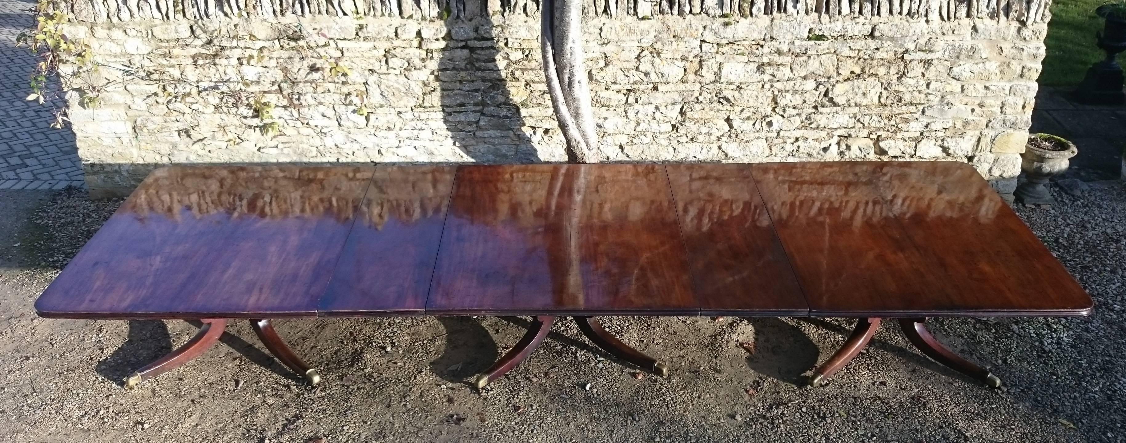Antique three pedestal dining table made of huge sheets of really fine quality Cuban mahogany. This table has it all, excellent color and patination, a wonderful country house scale and outstretched legs which terminate parallel to the ground. The