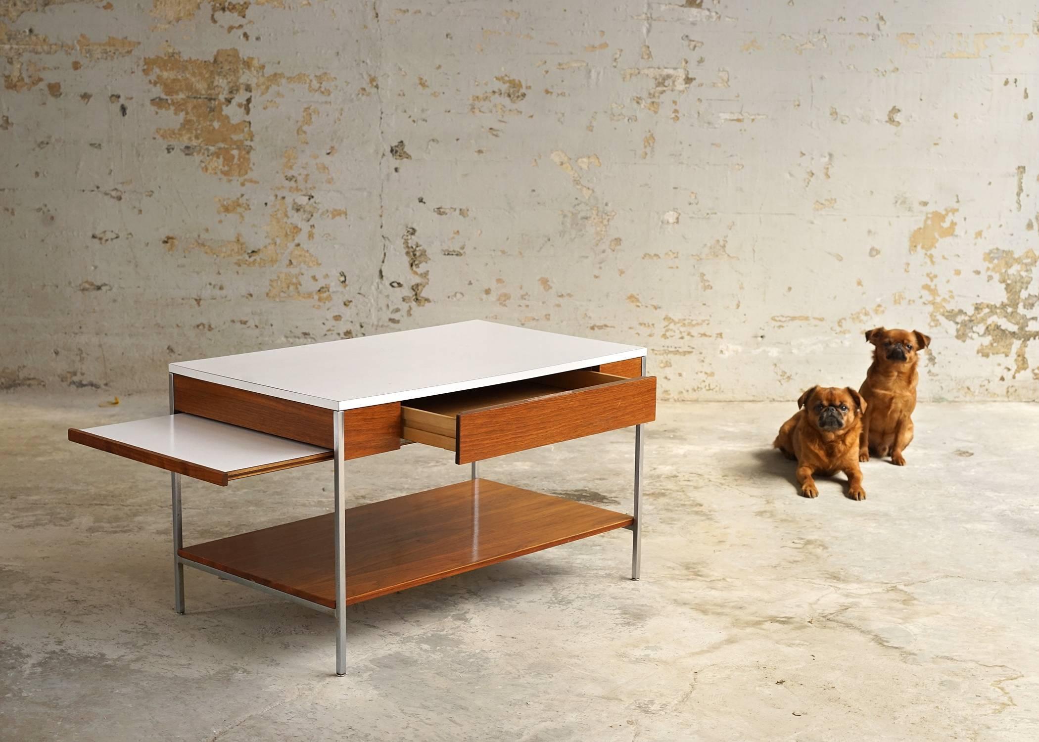 Versatile and multifunctional. Finished back allows table to float in a room if the occasion should require. Richly toned wood contrasts nicely with metal legs and white formica top. Features single drawer and 18.75