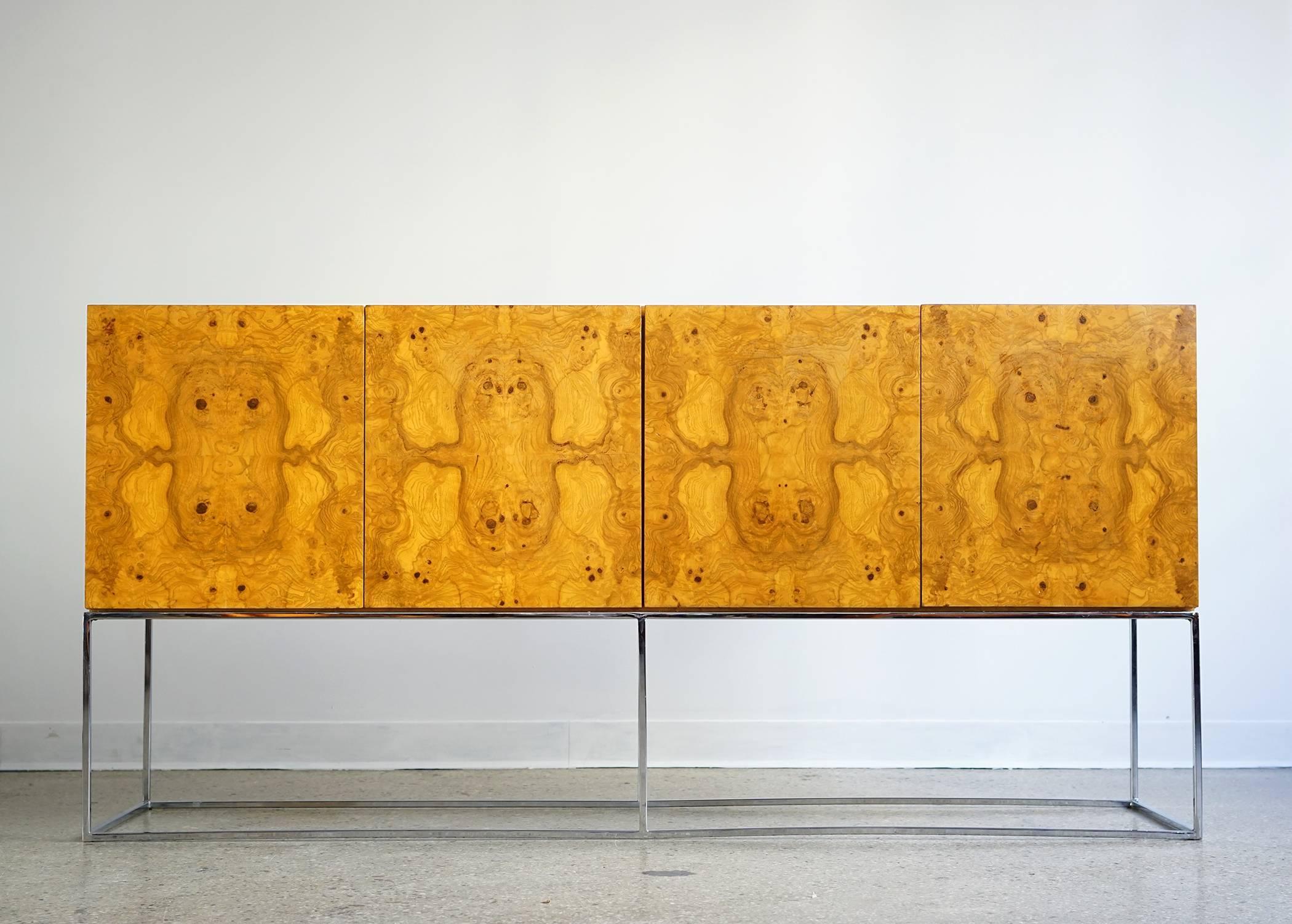 Beautifully figured bookmatched burl cabinet elevated on bright, polished steel, thin tube frame. Newly refinished and in fine vintage condition.