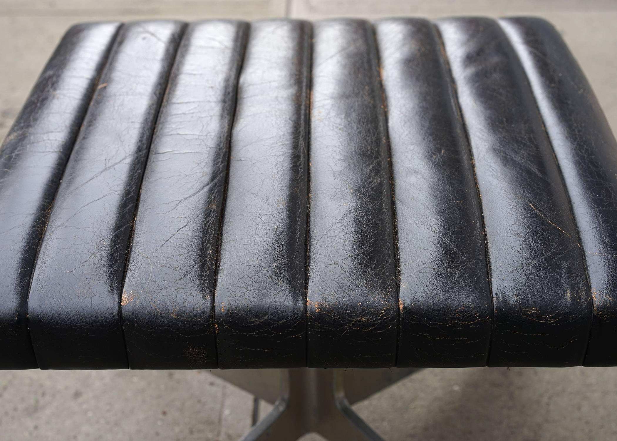 Elegantly handsome with clean, modern lines and original channel tufted leather upholstery. Lovely natural patina. Versatile as a stool or ottoman.