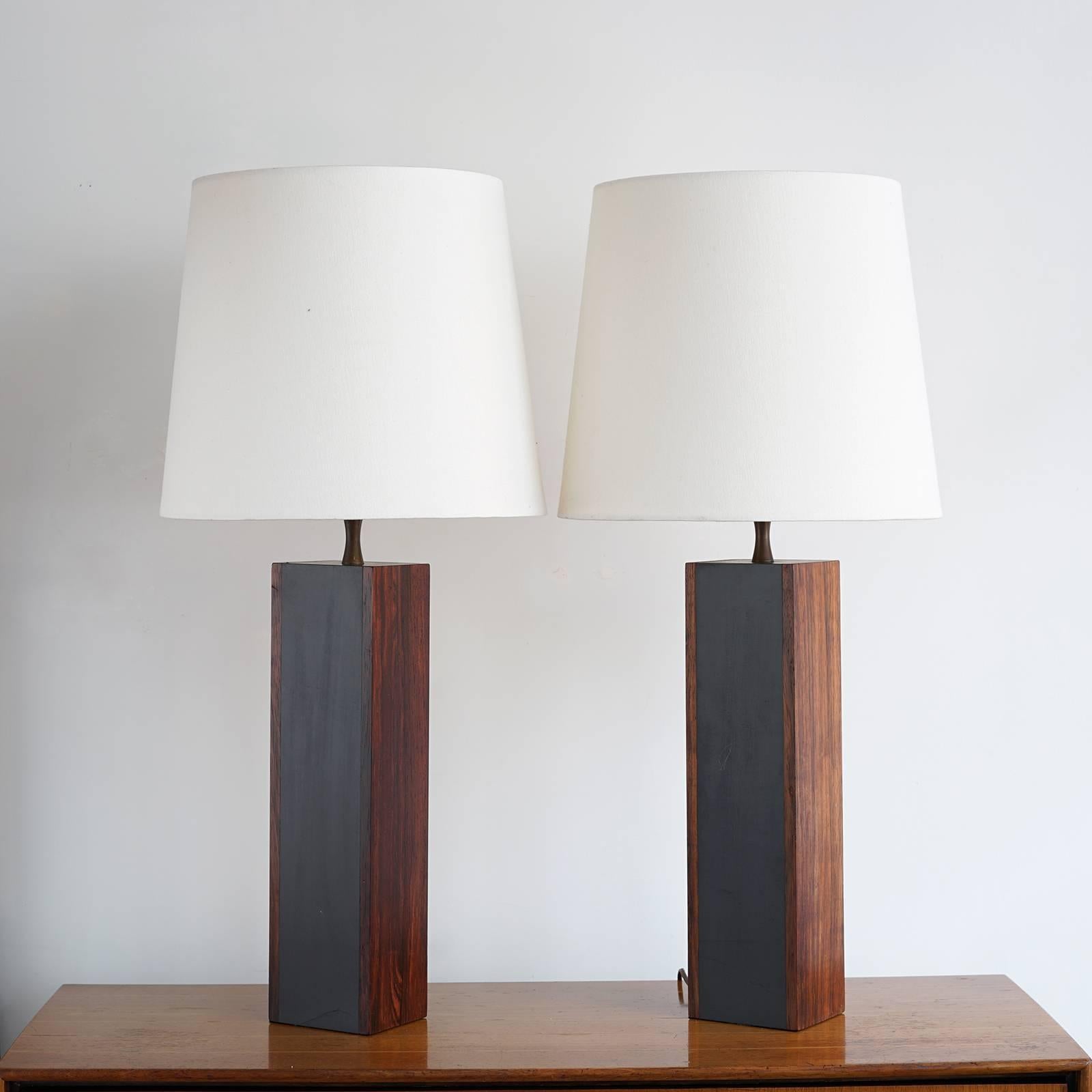 Elongated box form tower bases with solid Brazilian rosewood slabs to the front and back, contrasted by grey-black panels between. Highly figured wood grain and rich tone and color. Original sockets, harps and finials. Newer white fabric shades.