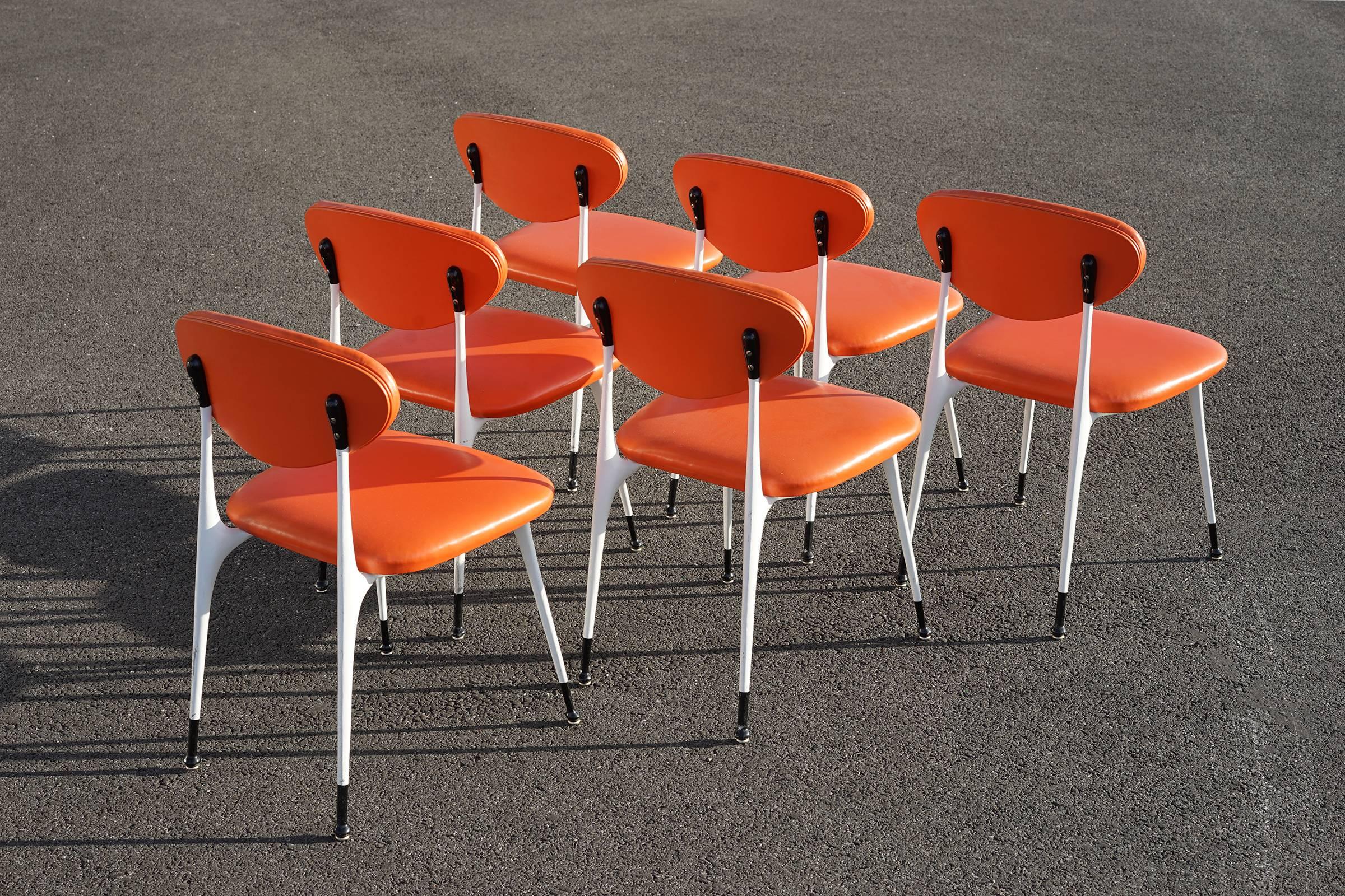 Sturdy and comfortable chairs feature cast aluminium frames with rare, original black and white finish and original, bright orange vinyl upholstery. Shown with matching extension table sold separately.