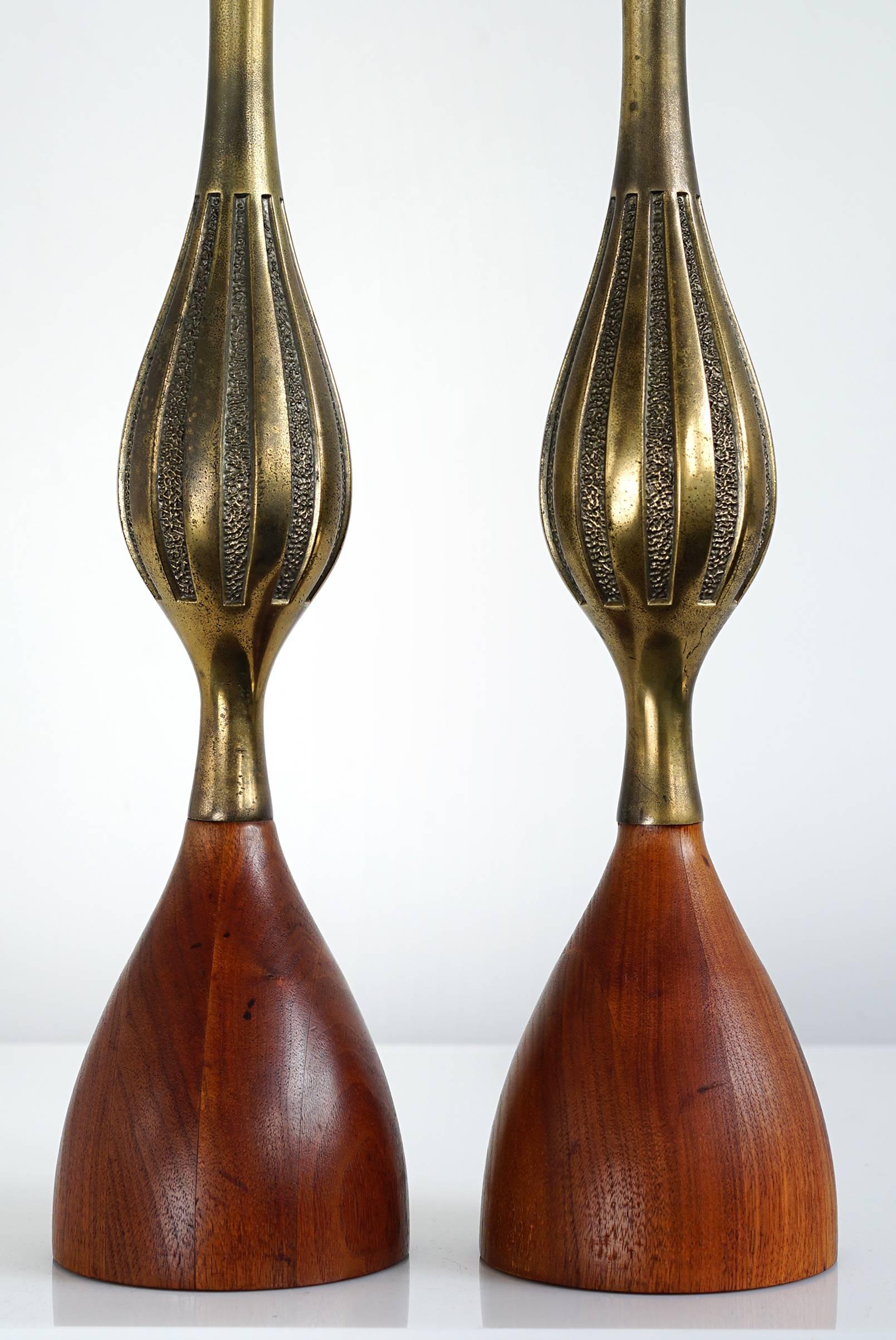 Tall, sinuous sculptural form in brass and stacked walnut. Original finials and harps. Handsome pair with lovely patina.

Measures: Height to bottom of socket 21.5 inches
total height 32 inches
diameter 5 inches.