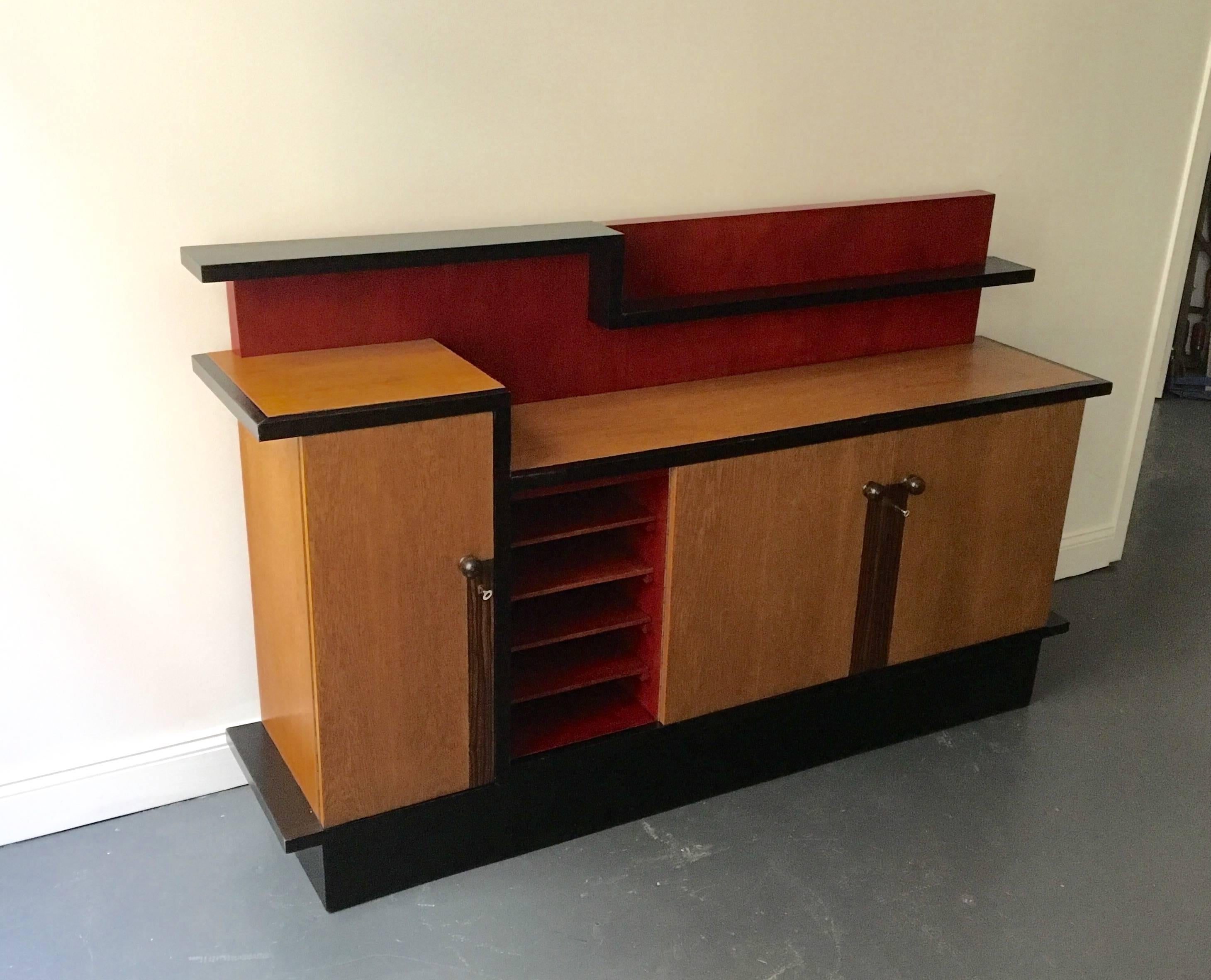 Designer: Coen de Jong
Manufacturer: A.J. Boskamp
   The cabinet is made of oak and coromandel with ebonized and red stain wood. The asymmetrical cabinet has three doors that open to shelves and in addition, red exposed shelves visible in