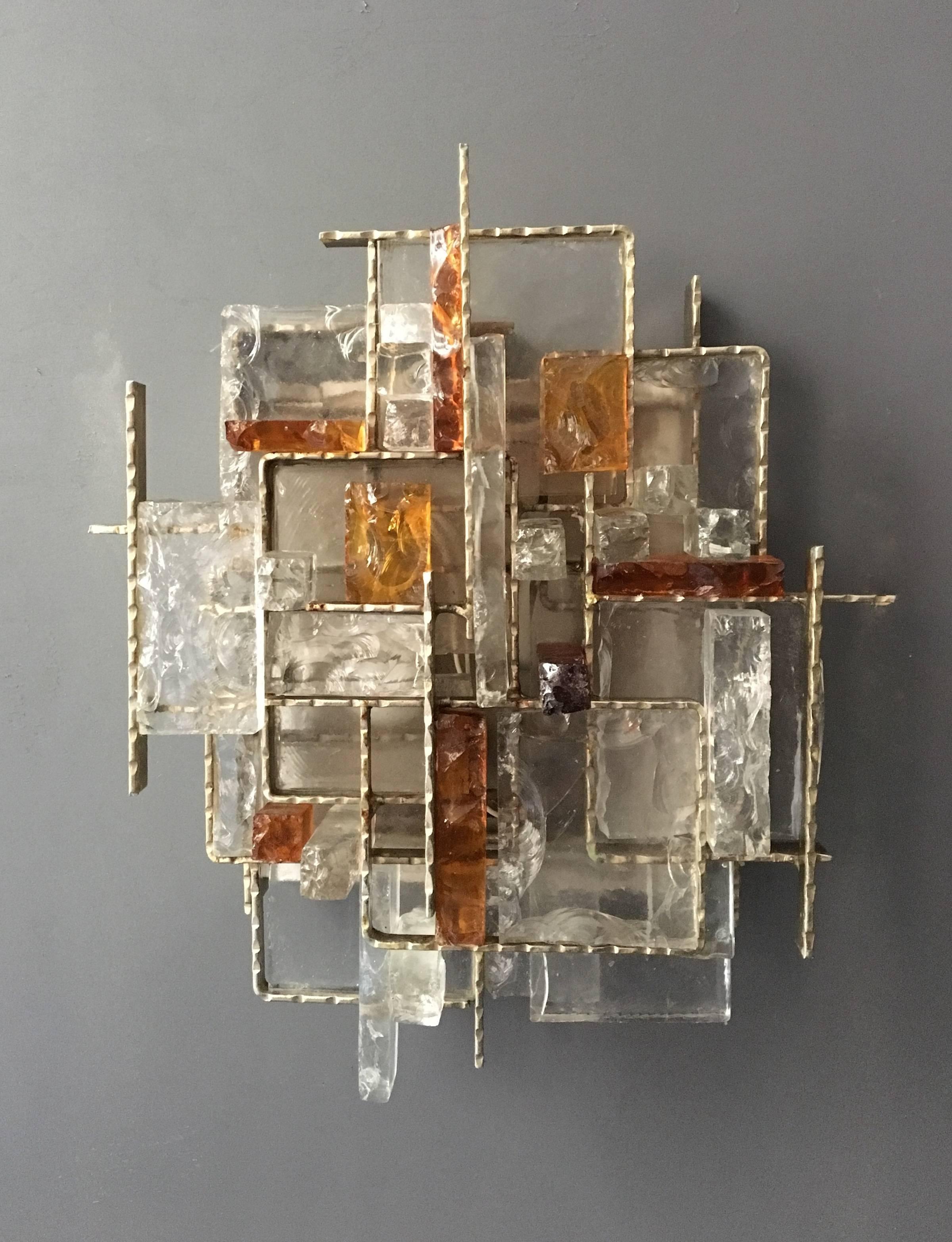 The complex layering and placing of glass and metal creates a wonderful lighting affect and a work of art. This is Albano Poli at his best; re-inventing objects of lighting and an ability to master the materials. The sconces has two internal