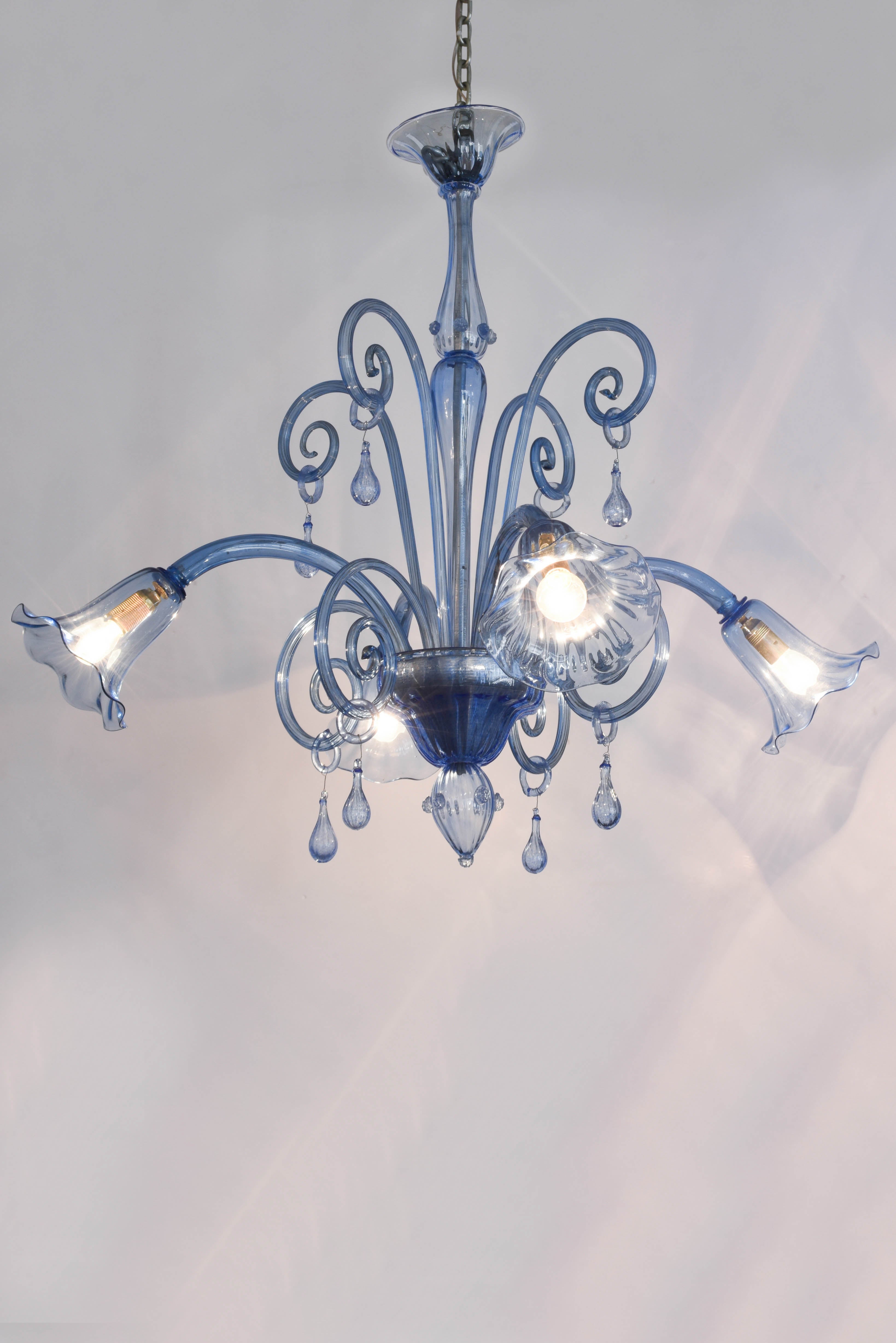 Light blue Murano glass chandelier with four arms. Blown glass with bells. 1950s. Diameter 90 cm  x 90 cm height