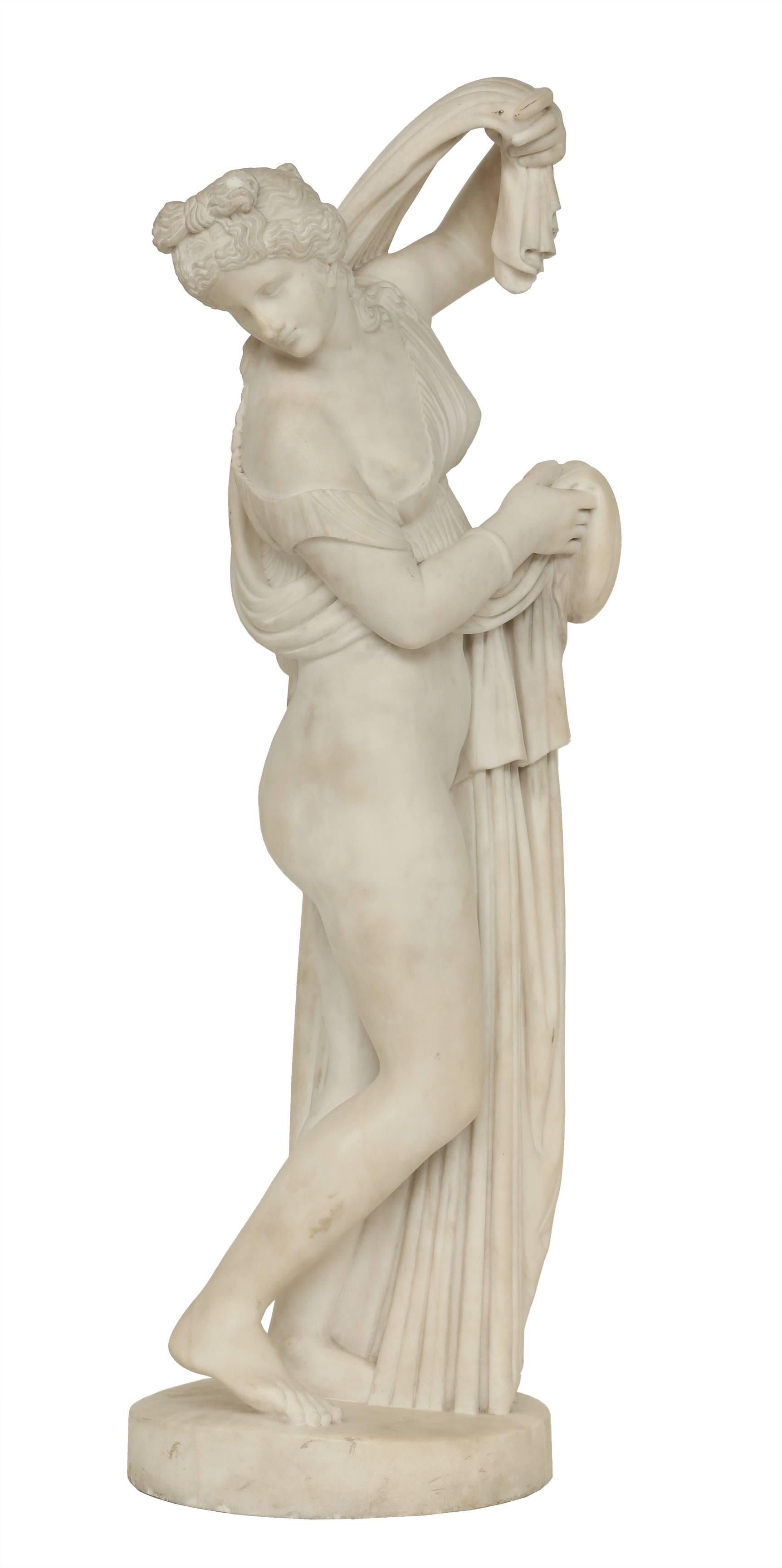 An exquisite Italian early 19th century white Carrara marble sculpture of Venus Callipyge, signed J VACCA NAPOLI 1809. The statue is masterfully sculpted out of one solid piece of marble. The elegant maiden is raised on a circular base, draped in