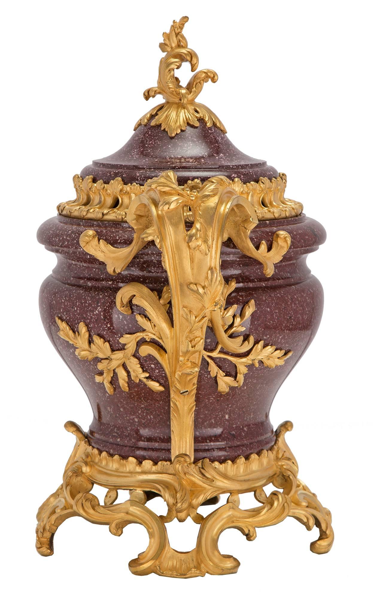 An exquisite and very high quality French 18th century Louis XV period Porphyry and ormolu lidded urn. The urn is raised by a sensational and richly chased pierced ormolu base with lavish scrolled designs, and supports centered by a fine seashell