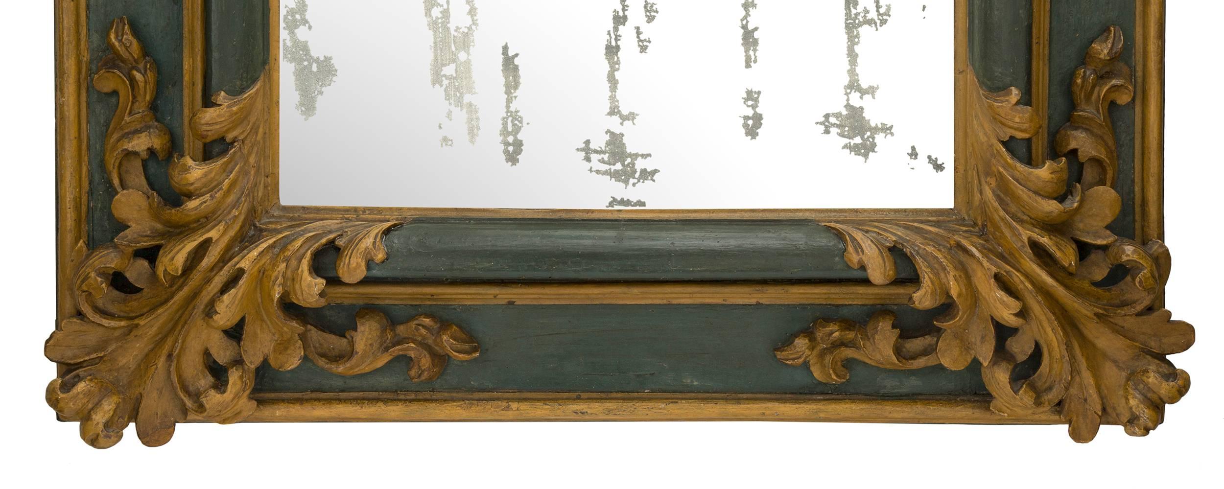 A pair of very handsome and unique Italian 17th century Baroque period patinated mirrors. Each mirror has a dark green patinated frame with molded edge golden borders. At each corner is a large very opulent and wonderfully carved scrolled golden