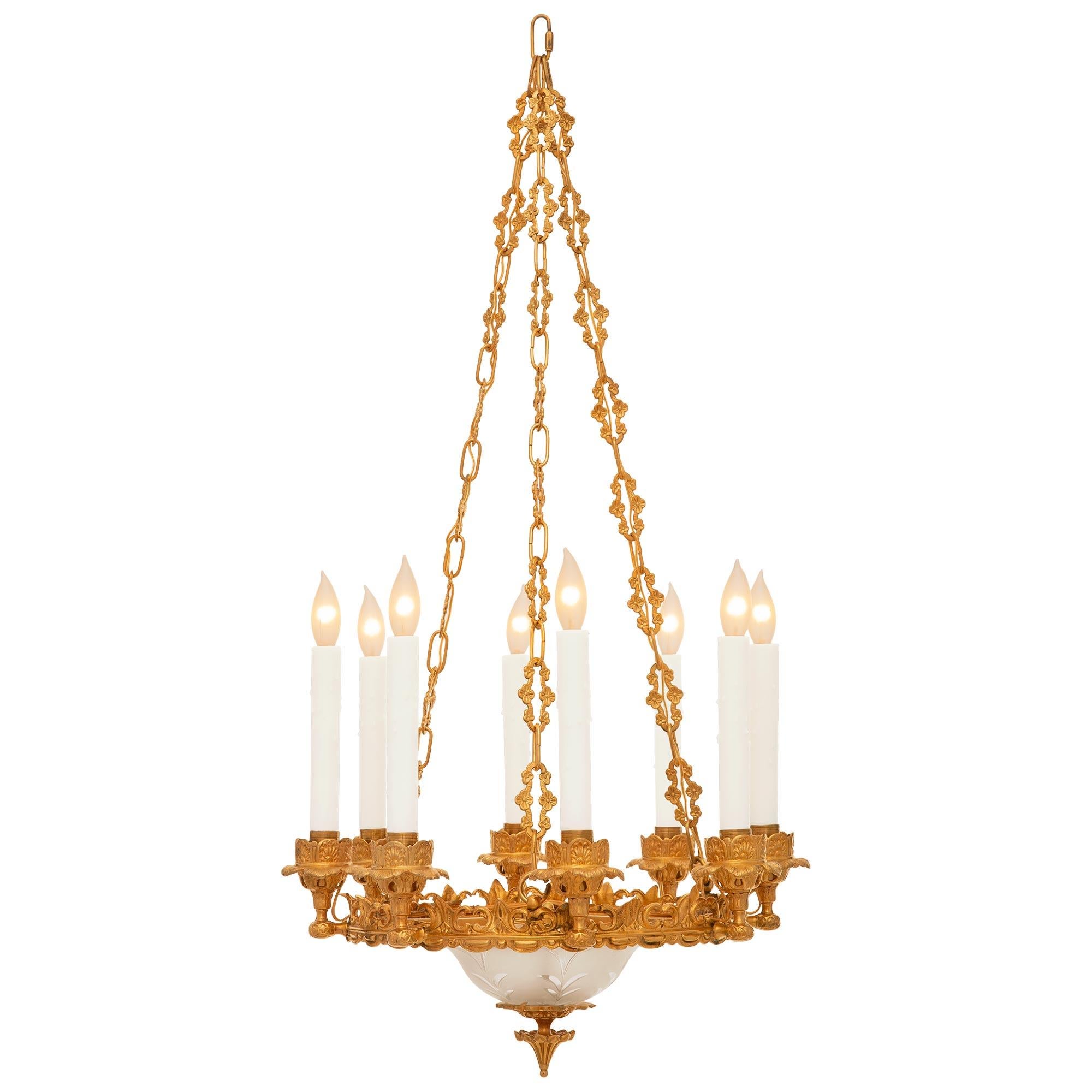 Una bellissima e decoratissima coppia di lampadari francesi del XIX secolo in Ormolu e vetro acidato. Ciascun lampadario a otto bracci è centrato da un grazioso terminale in Ormolu con motivo a reticolo e fogliame nella parte inferiore, al di sotto