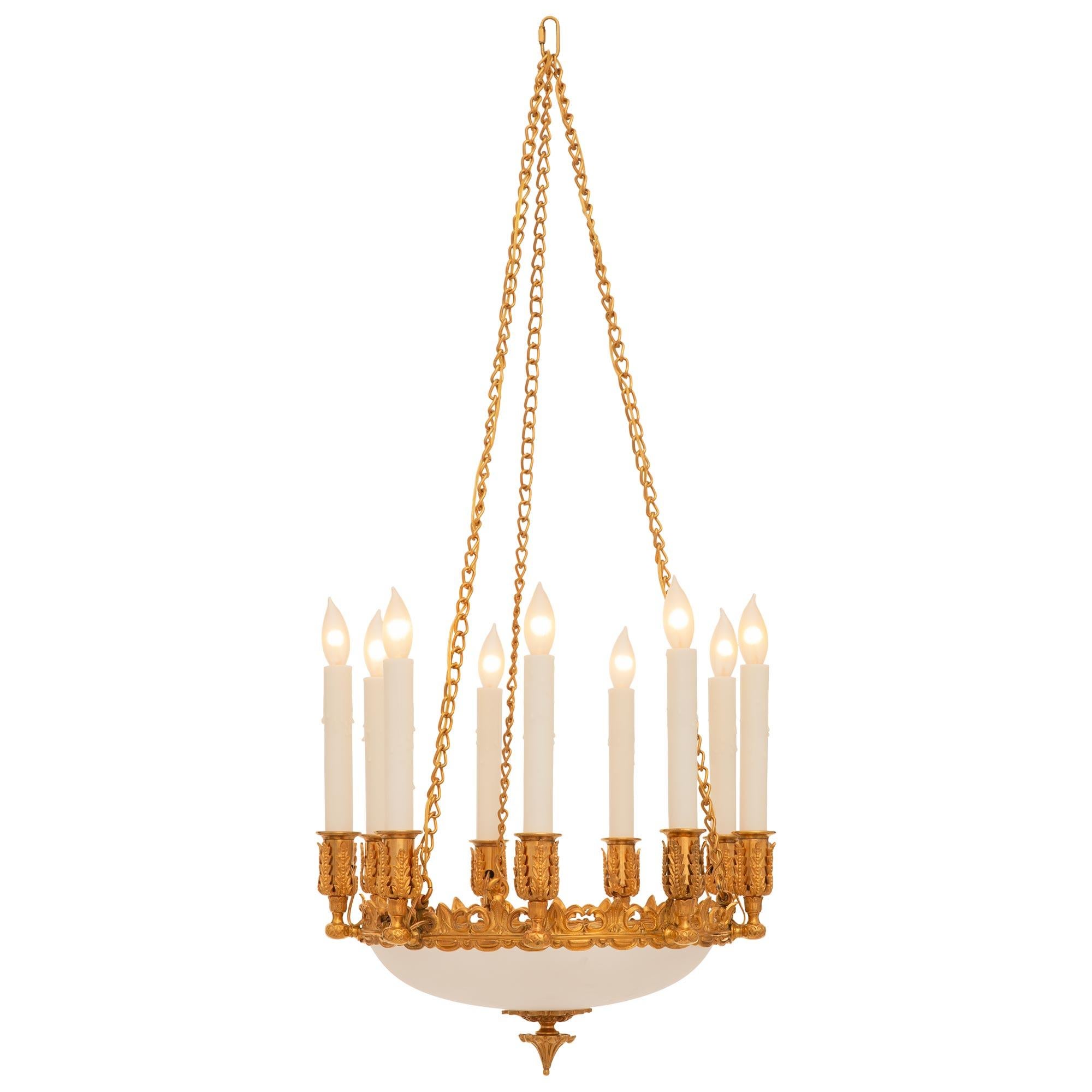 Un lampadario francese del XIX secolo molto decorativo in Ormolu e vetro smerigliato. Il lampadario a nove bracci è centrato da un grazioso finale in Ormolu con reminiscenze e foglie al di sotto della bellissima coppa in vetro smerigliato. Il bordo
