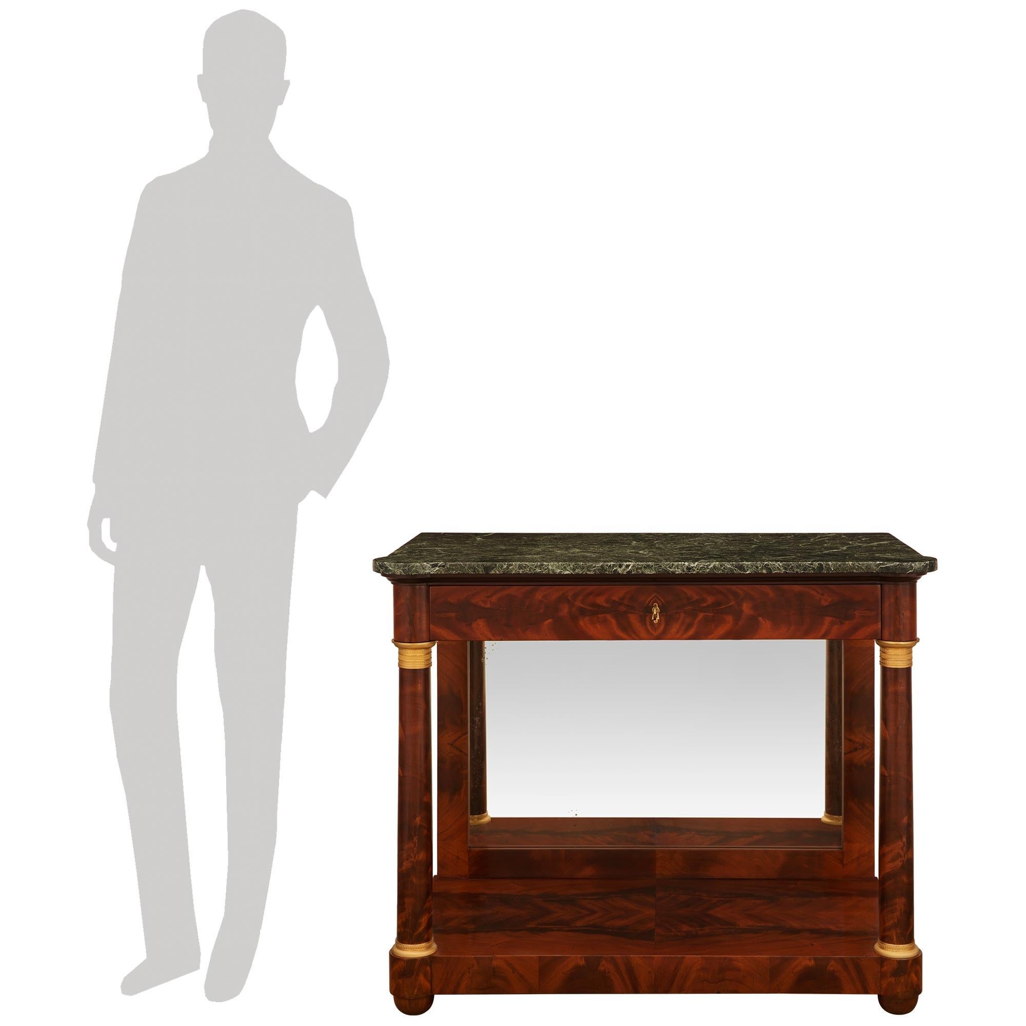 Très belle console de style Empire/Néoclassique du 19ème siècle. Console en acajou flammé et bronze doré. L'étonnante console à dessert repose sur des pieds en forme de chignon en acajou massif, sous un épais et impressionnant plateau inférieur en