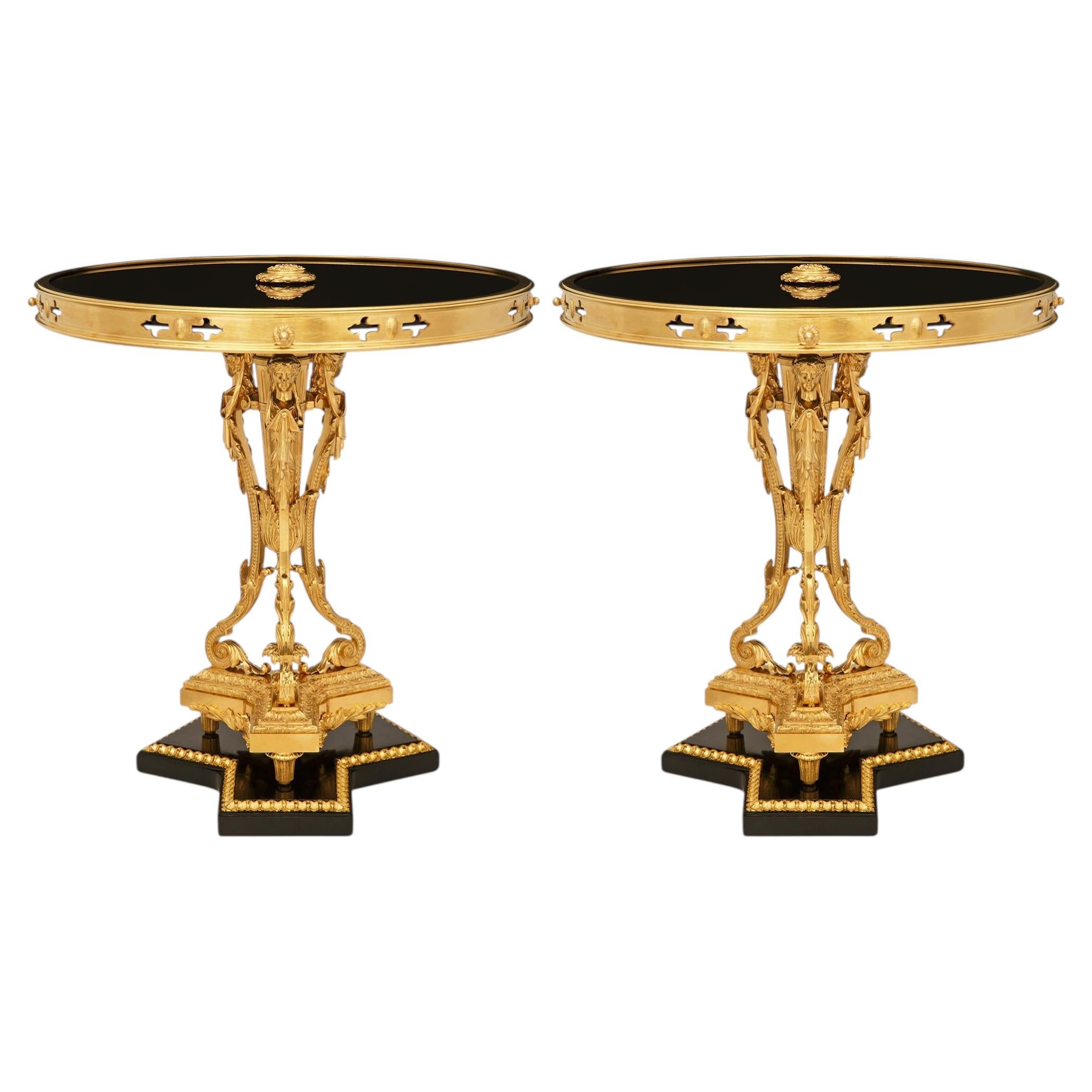 Par de mesitas auxiliares francesas del siglo XIX, de estilo Luis XVI, de madera dorada, bronce dorado y cristal
