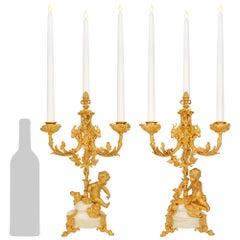 Una coppia di candelabri francesi in stile Luigi XVI, in bronzo dorato e marmo bianco di Carrara