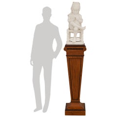 Una estatua de mármol de Carrara firmada por Lapini, con un pedestal inglés de estilo Regencia de madera de satín
