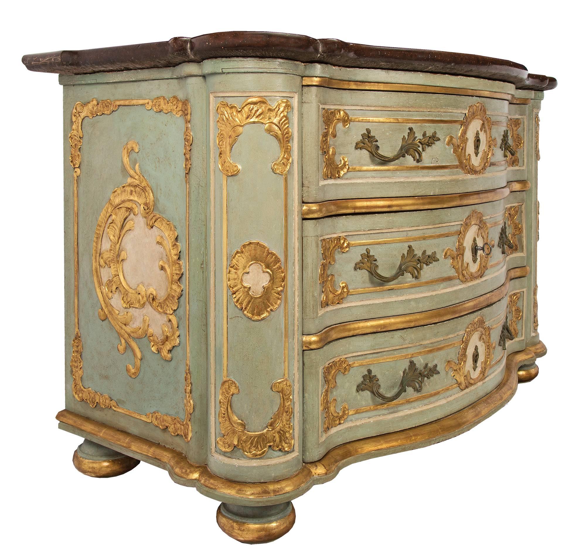 A sensational Italian mid-18th century Louis XV Period three drawer patinated and giltwood Venetian chest. The chest is raised by patinated bun feet with a giltwood band. Above the convex scalloped giltwood frieze are three richly decorated drawers