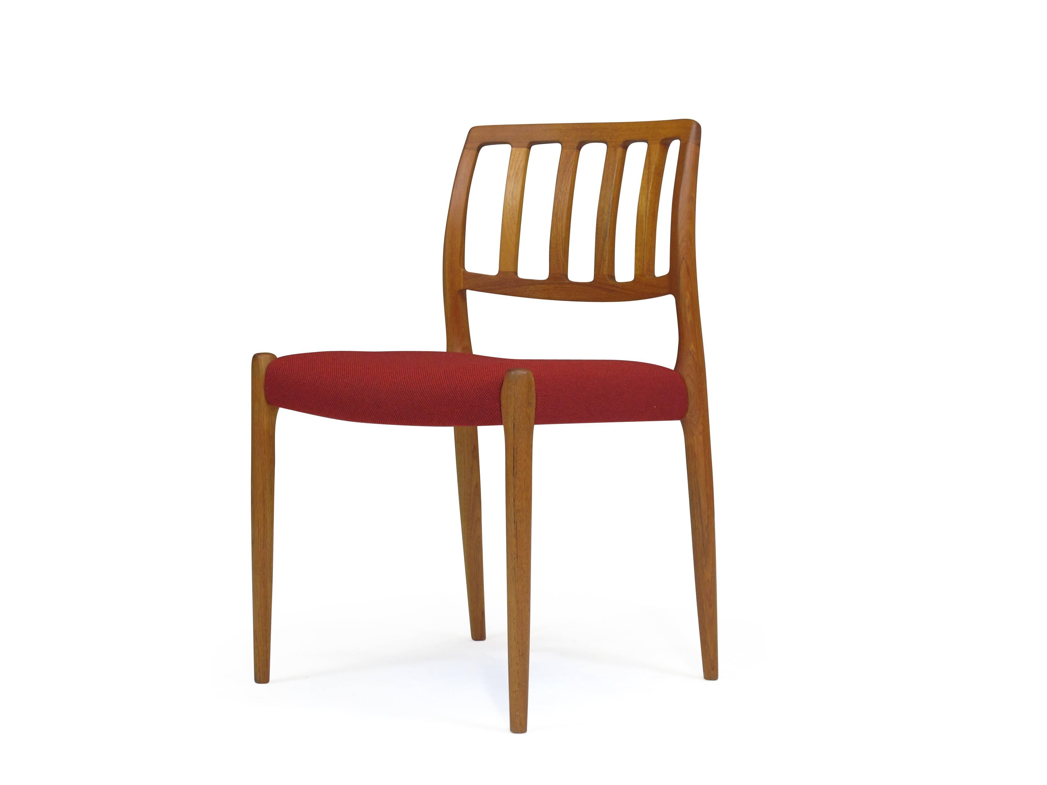 Mid-Century teak dining chairs designed by Niels Otto Møller for J. L. Møller. Model 83. Newly upholstered seats in a traditional red wool textile. The chairs have been professionally restored and in excellent condition.